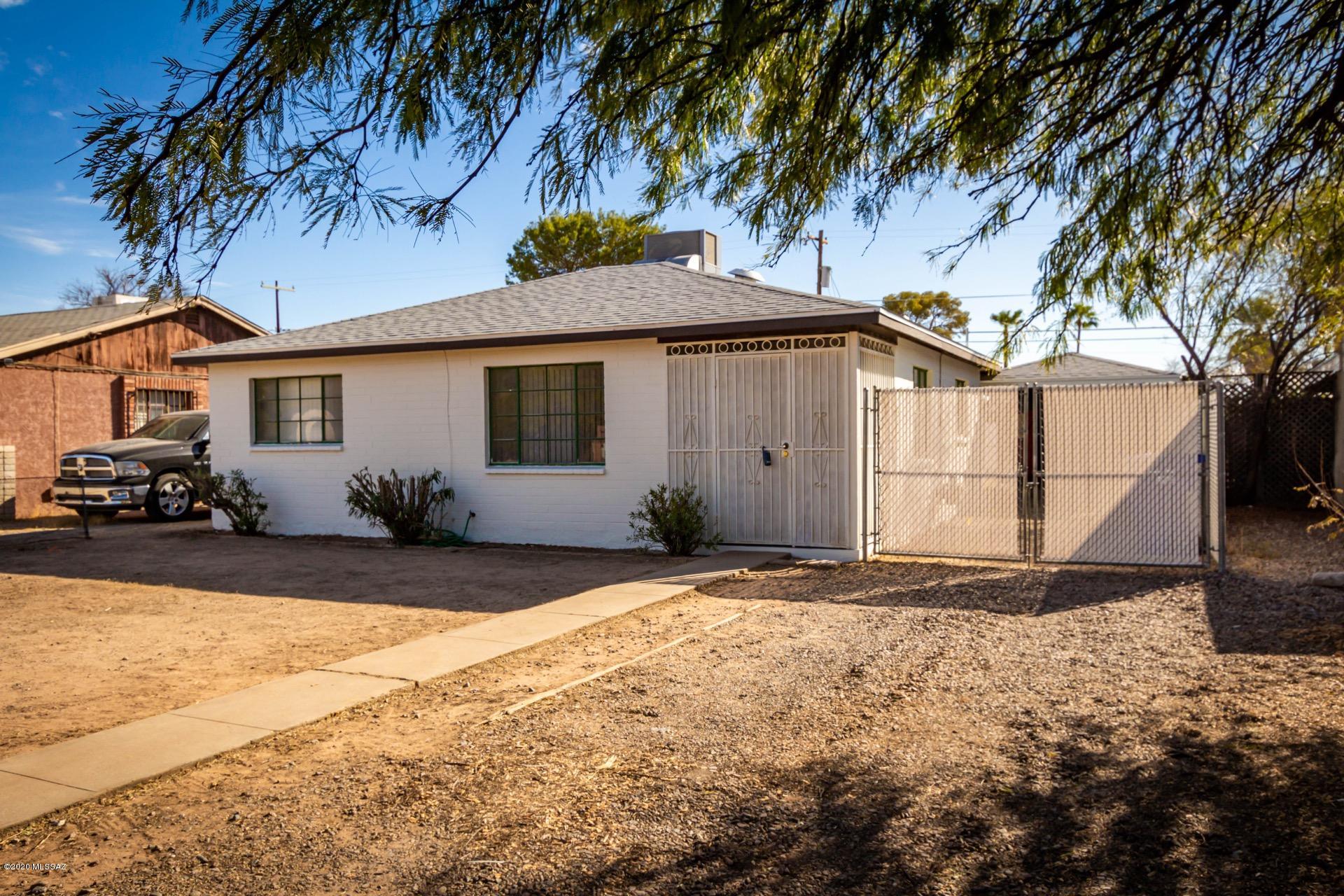Incredibly charming 2 bedroom, 1 bath home with tile floors throughout, soothing palette, window blinds, & formal dining area.  Tiled kitchen counter, double sink, patio access, & white cabinets w/hardware. Generous size bedrooms, large closets, & pristine retro updated bathroom. Large interior laundry room. Charming screened in entry. Large backyard with room for a pool or guest house, covered patio, carport, RV Gate, & decorative stone. Close to Downtown, U of A, Reid Park & more.