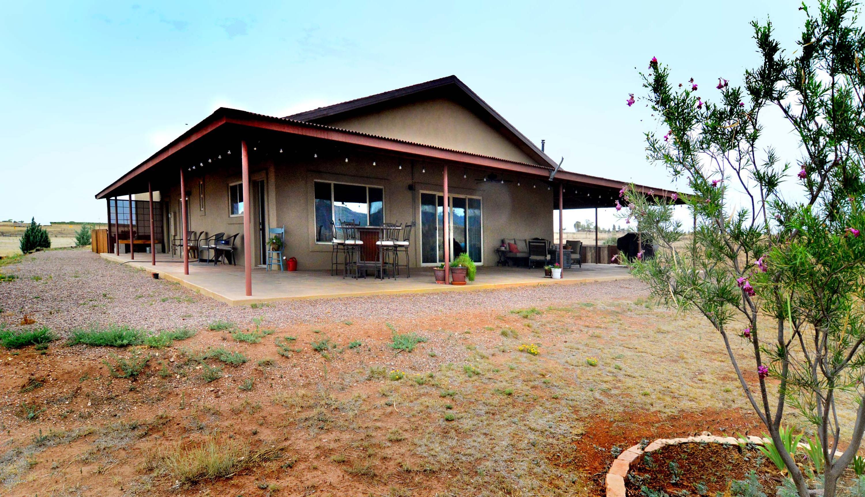 A must see property & setting w/premier details & ultra-comfortable proportions ~for full OR part-time living. This handsome 1612sf Territorial Ranch home has 2Be & 2Ba, gracious GreatRm w/10' ceiling & o/s windows overlooking nearby MUSTANG MTNS. Attached is a pristine 1600sf extend-length 4car Garage-WkShp w/12' ceiling & o/s 'Lift Master' doors. Frame stucco construction w/asphalt shingle roof (22gage metal over porches); metal-clad facia & enclosed soffits. 6'' thick colored concrete flrs w/rebar every 2'; concrete counters t/o w/copper sinks & gorgeous artisan cabinetry + knotty birch cabs & alder drs; footed slipper tub; cent. vac. 10' deep cvd wrap-around porches; 8'x12' Studio-GardenHouse; no-climb fencing on 2 sides + pipe fencing w/welded wire & artisan-made auto-gate @ entrance.