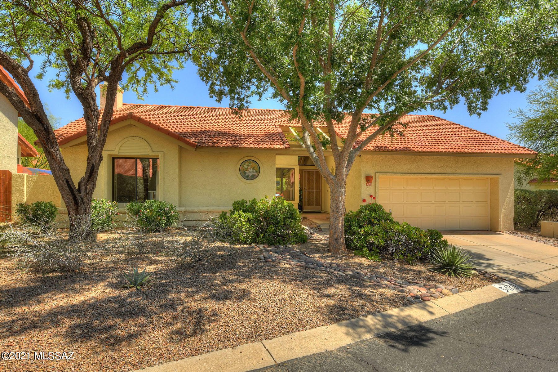 Artist retreat filled w natural light & vaulted ceilings. Split bedroom plan with an updated master shower & master bdrm opens to the back. Three bdrm or two bdrm w den. SS appliances in kitchen w plenty of cabinets & counter space. Walls of windows highlight the professionally landscaped garden. Brick pavers in backyard w artistic wrought iron wall detail, mature plantings &  mural on the block wall. Property backs to common green space for additional privacy. Cool off at the community pool & spa. Garage w storage cabinets & sink.  Near restaurants, golf, hiking, & shopping & Sabino Canyon.