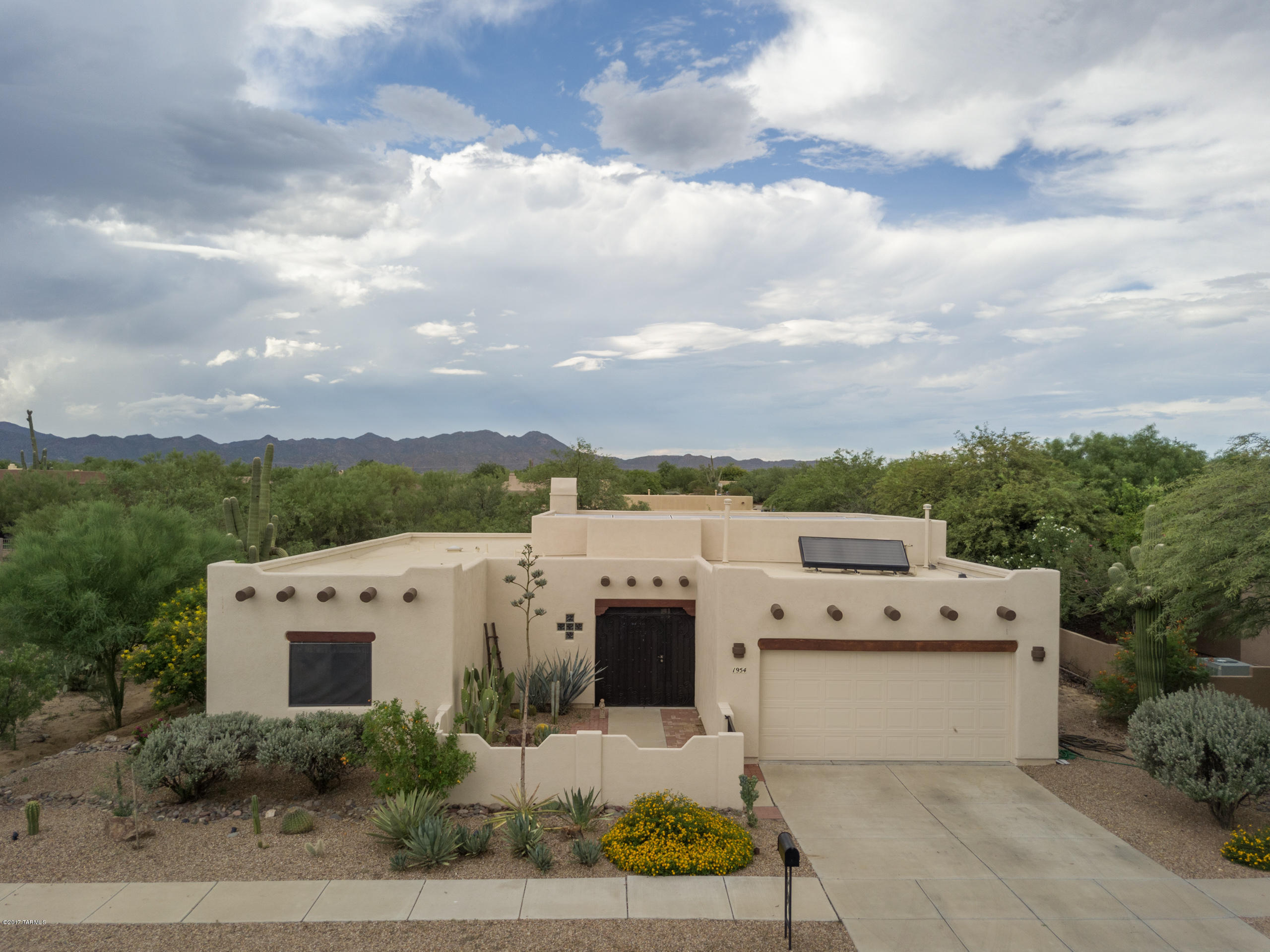 Beautiful Santa Fe style home in Oro Valley is ready for move in! This 3 bed 2 bath is the floor plan, location, and privacy you have been waiting for. Open floor plan with high ceilings wood beams and tons of natural light. The rich warm cabinets in the kitchen and bathrooms have been refinished and new 2 tone paint throughout the home as of August 2017. The large master bedroom overlooks the pool with a private entry to the patio, spacious master bathroom, and large walk-in closet. With almost a half-acre, this home has privacy that is hard to find. The green and grassy backyard is a little oasis in the desert with a beautiful pool, trees and surrounding saguaros. Leased solar panels are an extra bonus for a very energy efficient home! Located within walking distance to schools K-12.