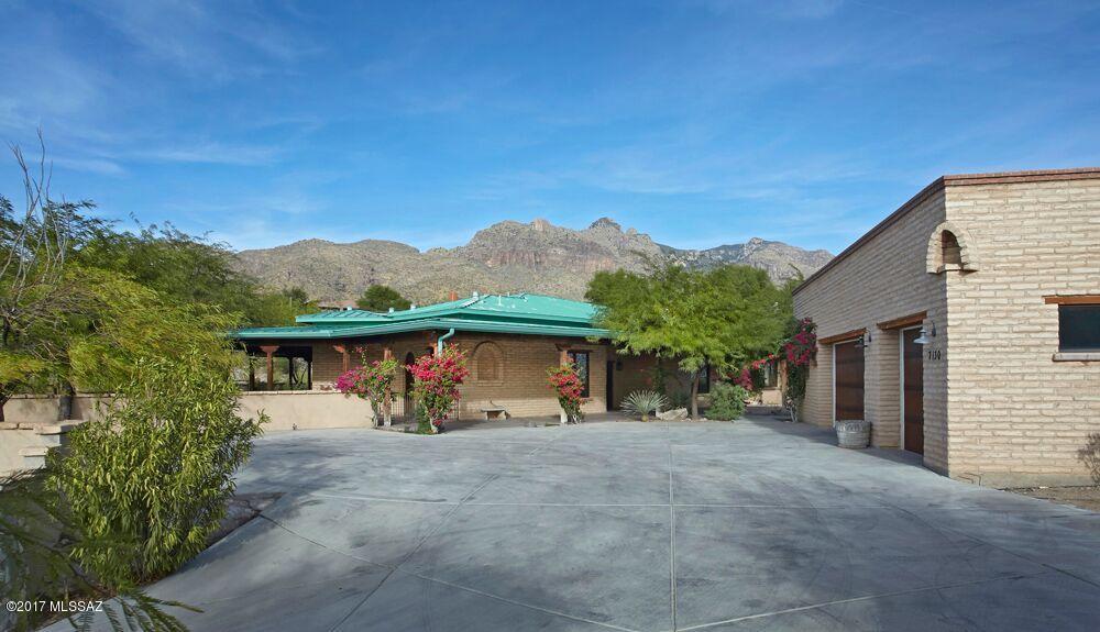 SERIOUS PRICE REDUCTION - OWNER SAYS SELL!!! AMAZING OPPORTUNITY ON THIS HALLMARK MUD ADOBE HACIENDA PERCHED HIGH ON A HILL IN CATALINA FOOTHILLS WITH  EXPANSIVE MOUNTAIN VIEWS. HUGE GREAT ROOM WITH STONE FIREPLACE, CONCRETE FLOORS, BEAMED CEILINGS, VENETIAN PLASTER AND LOTS OF FRENCH DOORS OUT TO WRAP AROUND COVERED PORCH WITH ANOTHER STONE FIREPLACE. WONDERFUL OPEN KITCHEN WITH SIX-BURNER WOLF RANGE, SUBZERO, STAINLESS FARM SINK AND BEAUTIFUL GRANITE COUNTERS. GIGANTIC GREAT ROOM ACCOMMODATES TWO SEATING AREAS AND GENEROUS DINING AREA. HUGE MASTER BEDROOM WITH FIREPLACE AND LOUNGING AREA. BEAUTIFUL MASTER BATH INCLUDING STEAM SHOWER AND LUXURIOUS CLOSET. THE THREE CAR GARAGE ALSO FEATURES A SEPARATE STORAGE AREA AND A POTTING ROOM OR WORK SPACE.