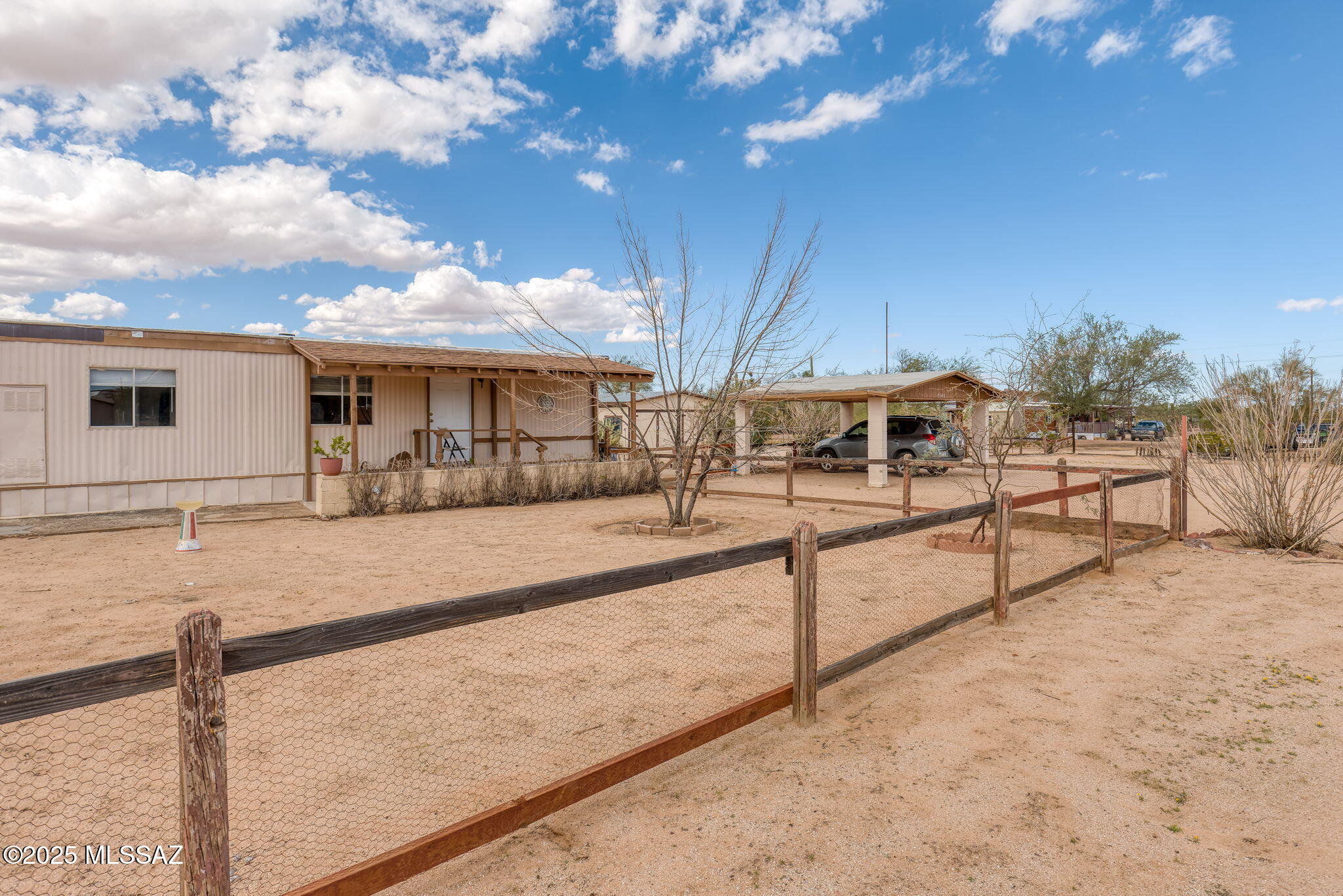If you're searching for a serene escape on a beautiful 1-acre property, this home could be perfect for you. Relax on the front porch or the wraparound porch in the back, soaking in stunning blue skies and panoramic views year-round. The front gates provide easy access to the backyard, where you'll discover an oversized, detached garage and workshop ideal for projects or extra storage. Plus, a private two-car carport at the front offers convenient shaded parking. Inside, this well-loved and meticulously maintained home welcomes you with a spacious kitchen, a cozy living room, and an oversized den—plenty of space to make it your own.