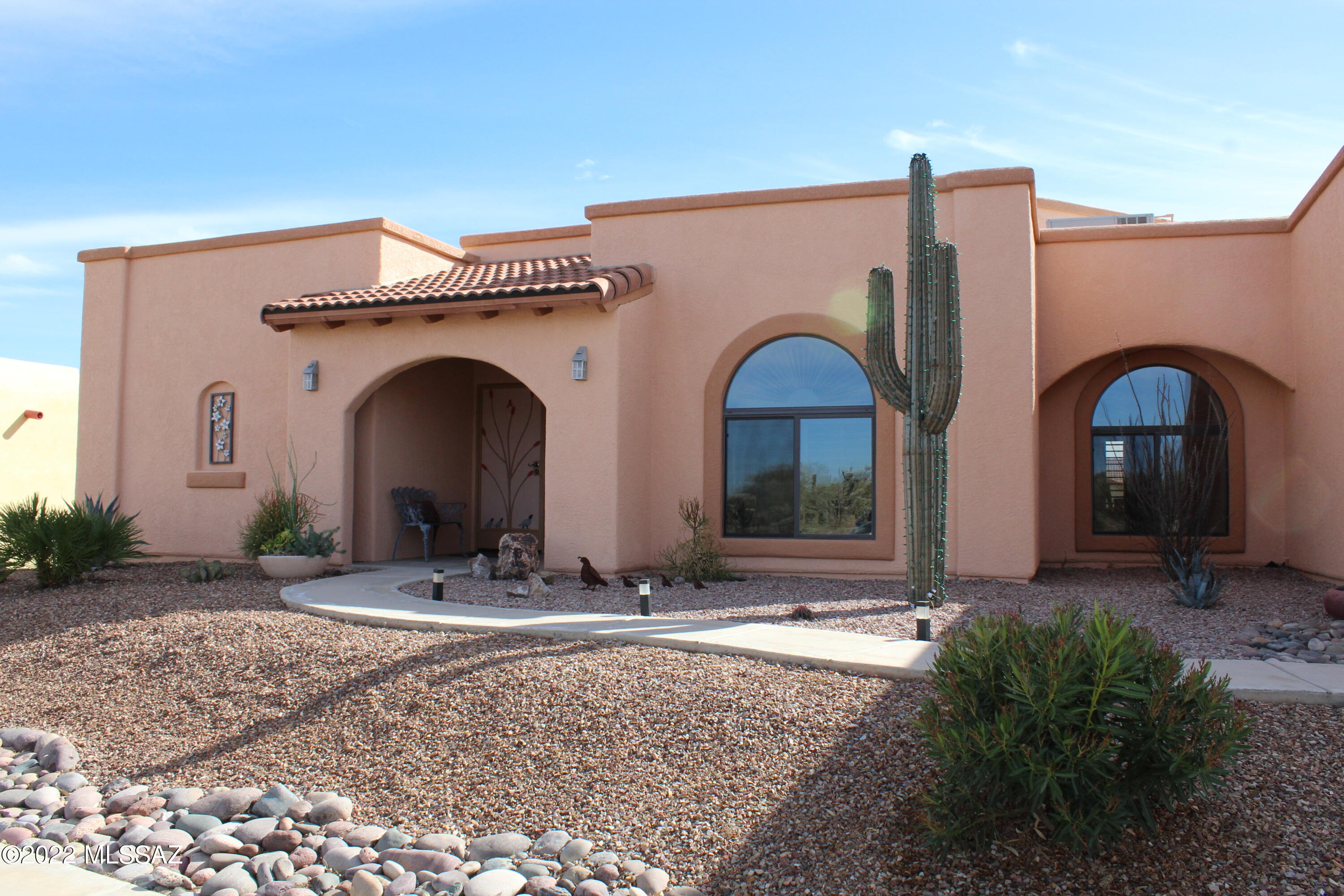 Welcome to your Old Pueblo Mission style, custom Pierce Home built 2x6 construction. Interior decor with Southwest style custom hand painted walls, completely tiled. Latilla ceiling in great room, accented with tall Kiva gas fireplace and clerestory windows. Stately wood beam and column frame the dining room. Ample kitchen with center island, Talavera pulls, gas range, new slate french door, & custom cabinets. Split bedrooms for guest visits. Spacious Master with Italian tile in walk-in shower & counter tops. Watch the awesome monsoons coming in over the Santa Ritas, sunrises and sunsets from the South facing screened porch year round. Tesla Solar Electric lease for only $79/month. New water heater in the extended garage equipped with extra storage.  Has GVR to meet your active life. 3rd bedroom is being used as a great den with a closet or formal dining room with grand double doors. Furniture & furnishings available with Seller approved offer of reasonable amount.