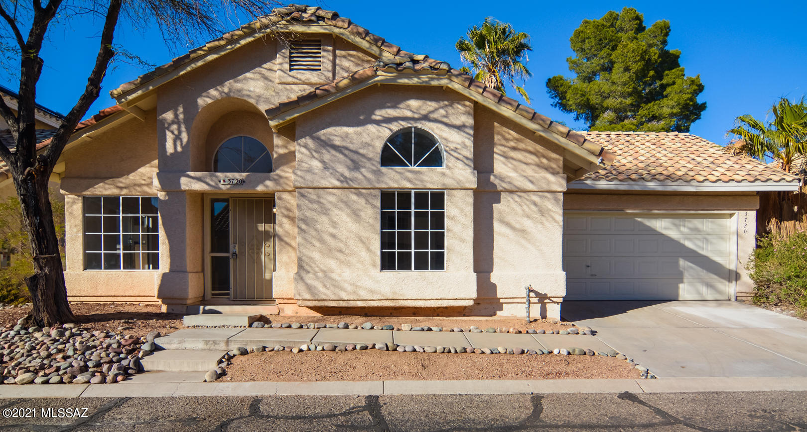 Vacant, sanitized and beautifully remodeled Contemporary style home. Located in a convenient Northwest Tucson location. Rich wood laminate flooring. New carpet and padding in bedrooms. Updated modern kitchen with stainless steel appliances and rich dark brown cabinets. New custom interior paint. Updated modern bathrooms with granite countertops. Owner's suite bathroom features walk in closet. Back porch features mature palm trees and vegetation. Upgraded door hardware and light fixtures. Two car garage HOA includes garbage collection, street cleaning and a community pool. This home shows beautifully.