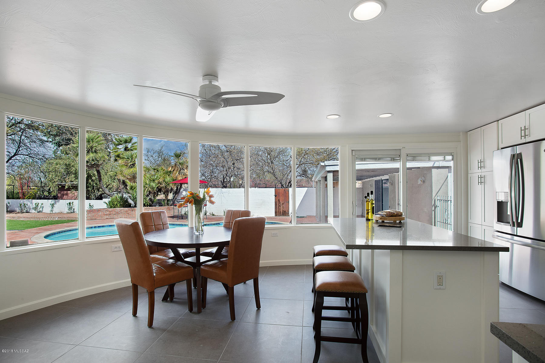 Welcome to your Palm Springs oasis in the center of Tucson. This beautiful renovation in the highly sought after Poet's Corner Neighborhood has it all. The gorgeous kitchen with custom white cabinets and quartz countertops is only topped by the grand curved window looking out into the massive backyard and pool. As you stroll into the master bedroom and once again see the incredible views, you will be awe struck by the spa-like master bathroom. Karastan carpet in each bedroom. The porcelain floors throughout, guesthouse, and wet bar are just a few more of the terrific features contained in this property. Get ready to fall in love with this throwback to the days of Frank Sinatra and Dean Martin that has been beautifully blended with modern amenities and a huge backyard to create the perfect home in the city.