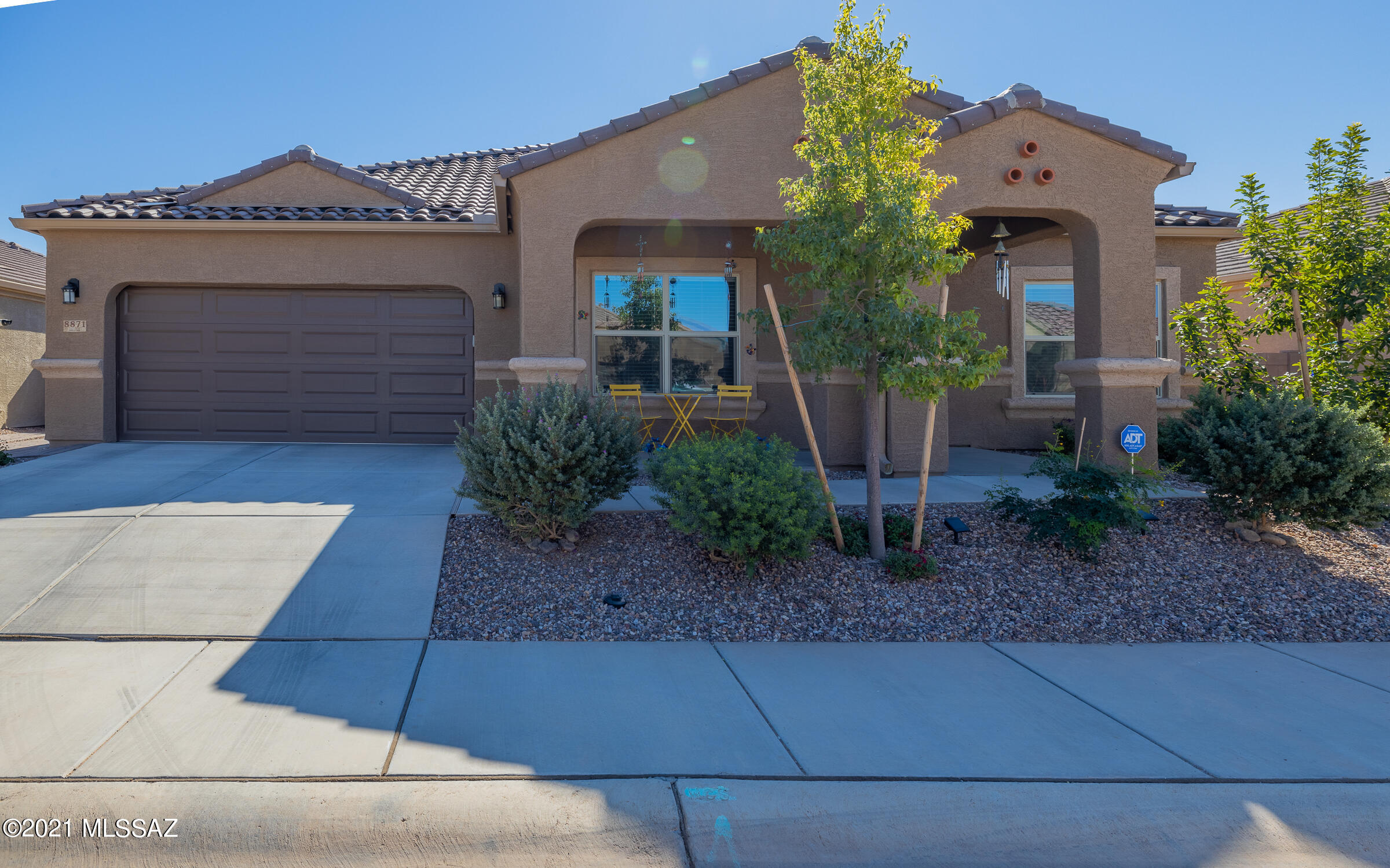 This elegant 2 bed, 3 bath, w/den & 2 car garage is breathtaking from curbside w/tile roof, mature vegetation, front porch, security door and tucked in gated community! The interior features a foyer, over-sized tile throughout (carpet in bedrooms), tall ceilings, window coverings, ceiling fans, solar shades, open floor plan, stylish kitchen w/staggered cabinetry, crown molding, quartz counters, stainless steel appliances, pantry, large island, electric in floor of great room, split floor plan, huge owners suite w/back yard views, owners bath w/double sink vanity, huge walk-in closet, walk in shower & direct access to laundry room from bath!  Back yard is an oasis w/turf, pavers, pergola, hot tub, irrigation & huge covered porch!  Community has parks, pool, gym, & much more!  WATCH VIDEO!!