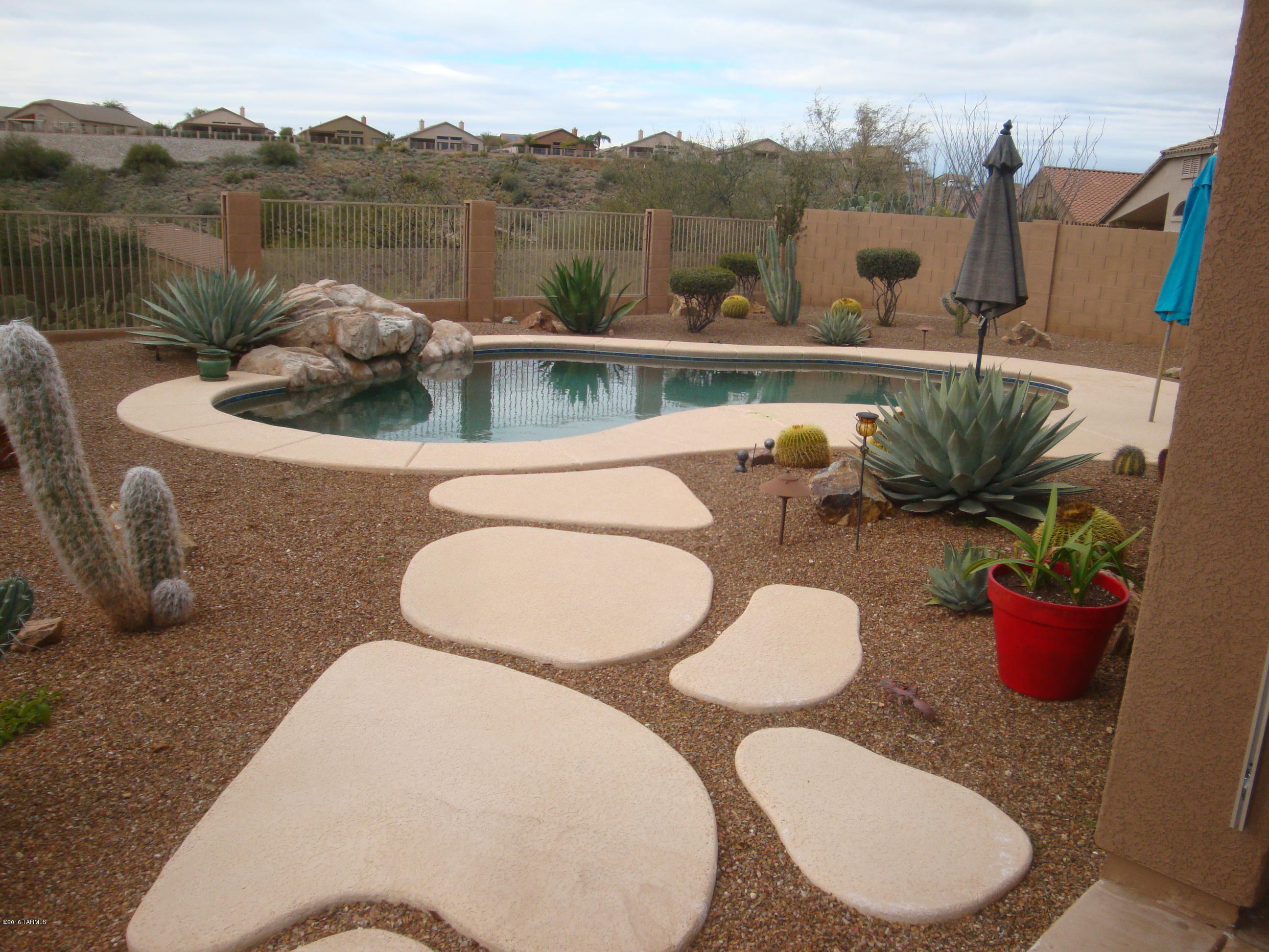 Don't miss the opportunity to own this home with fabulous views. Enjoy the spacious open floor plan. Large kitchen with butlers pantry.  Low care landscaped front, back, & side yards.  Side yard features producing citrus trees. Unobstructed  back yard views.  Pool, hot tub, Kiva fireplace and extended patio make for great outdoor entertaining. Electric sunscreens on patio. 2 AC units, water softener. Large master suite. Security screen door and alarm system installed. 
BOOK CASE IN DEN DOES NOT CONVEY
HOME SOLD AS IS.