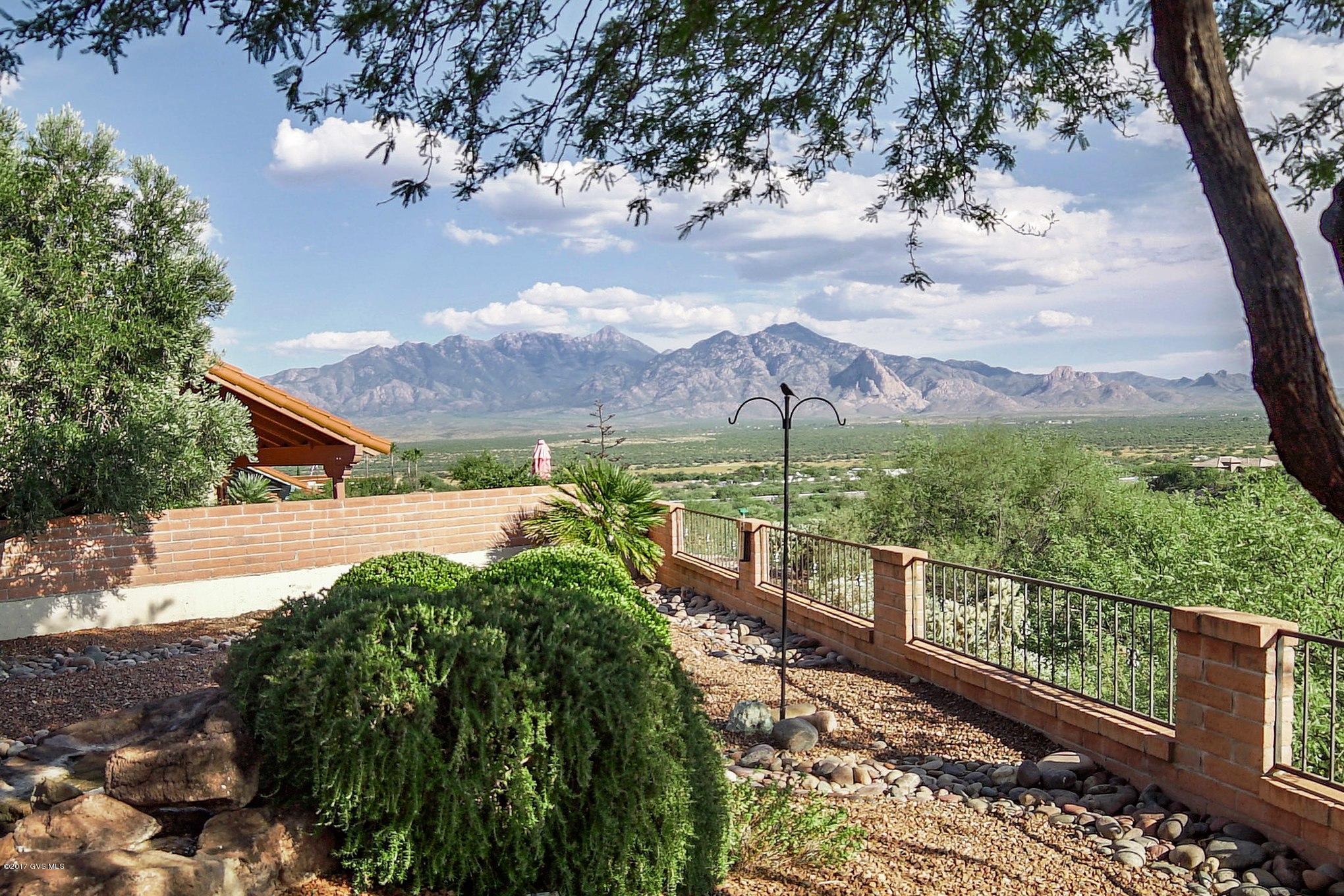 A beautifully maintained home with the Mountain Views that you are dreaming of! A Fairfield built home with classic red slump block construction - you'll pass through a quiet front courtyard to enter a spacious foyer drenched in natural radiance from a large overhead skylight. The living room is dressed in pastel colors that accent the cathedral pitched ceilings while displaying beautiful mountain views through a wall of triple sliding glass doors. Contemporary architecture utilizing cross beams, stretch across an adjoining dining room where you'll enjoy special meals with family and friends. The brilliant kitchen is encircled by abundant counter space with a convenient snack bar, traditional white appliances, an integrated Corian double sink and extends into a breakfast nook with  patio doors leading to the side wrap around patio. The master suite has an expansive sitting area, roomy walk-in closet, triple door patio access along with a large master bath offering dual sinks, extended counter space and corner soaking tub and separate walk-in shower. Your guests will enjoy the split bedroom arrangement and a spacious bath with both tub and shower. Double doors open into an executive den allowing for a quiet office or study. Relax on your shady covered patio surrounded by a warm red brick extension flowing out to a restful trickling waterfall with endless desert landscape views and the Santa Rita Mountains to the East. Sunrise and sunsets will be yours to enjoy every day!