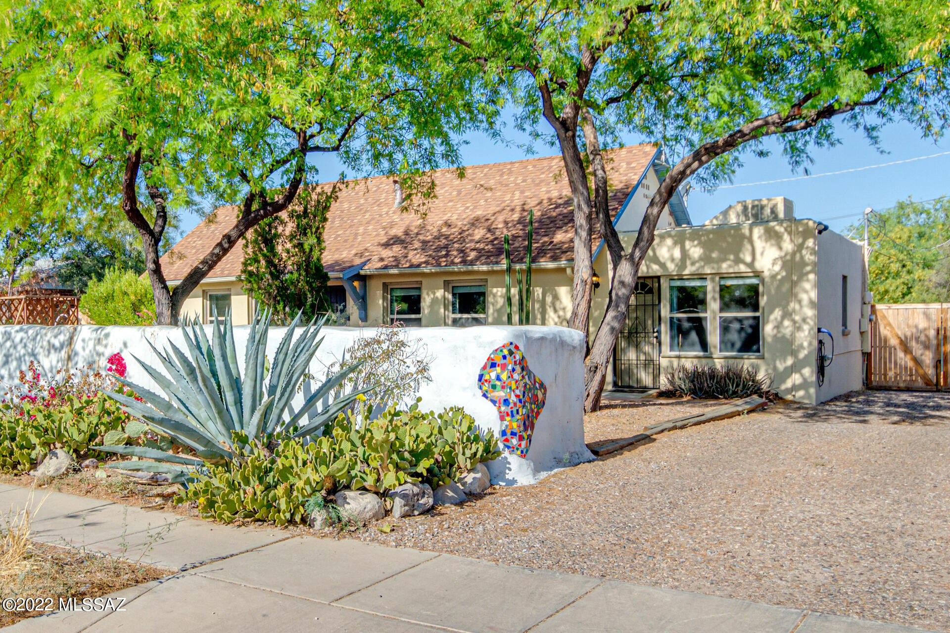If you've spent any time on 4th Ave or the Feldmans neighborhood, you will immediately recognize the iconic straw bale wall with mosaic tile.  Lovely 1945 bungalow features large lot with fruit trees, raised planters currently with wheat growing, grey water harvesting, LARGE 267 sq ft insulated storage building, primary bedroom/bath with separate entrance (great rental options), split bedroom plan, sunroom/laundry with space for dog crates, bike storage, office or more.  Nothing cookie cutter about this vintage home with modern improvements. Proximity to shops on 4th Ave, downtown, the UA and location in a historic district make this home very appealing.  Come check this one out before it's gone.