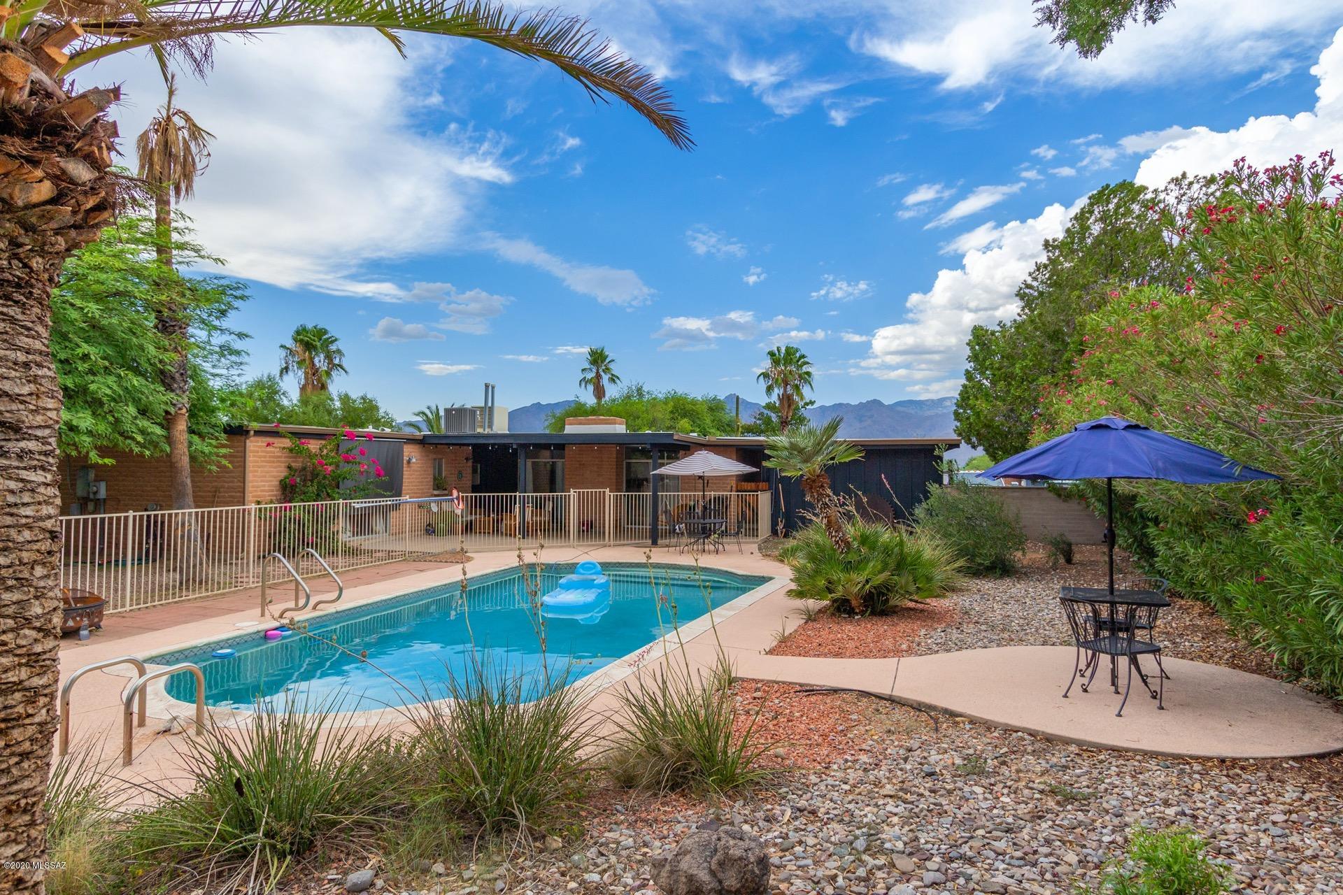 Outstanding Territorial Home situated on a large lot & surrounded by breathtaking Mountain Views. Serene backyard setting w/a sparkling fenced diving pool, covered patio, lush green landscape, shade trees, & endless blue skies. Soothing palette, handsome wood ''look'' tiled floors, arched windows, formal dining area w/upgraded lighting, window blinds, & brick fireplace for those chilly AZ evenings. Unique tin kitchen backsplash, SS appliances, stylish counters, pantry, & plenty of white cabinets w/hardware. Perfect home for entertaining inside & out. Plush carpet in all bedrooms, ample closets interior laundry room, & 2 pristine baths.  Will not disappoint!