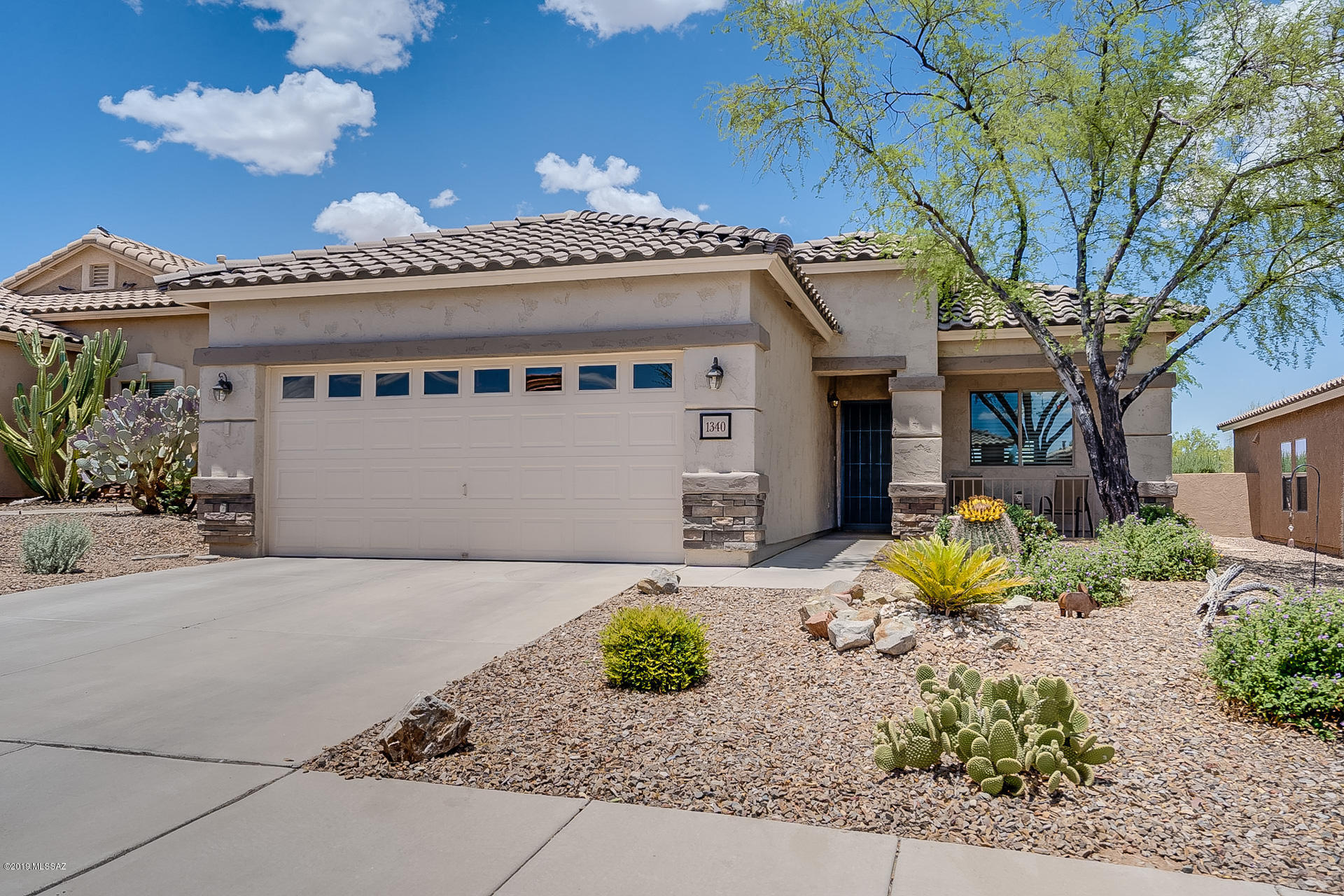 Hip roof lines along with stack stone accents give this home great curb appeal.  The living room has wood flooring and features built-in cabinetry with pullout drawers and built-in computer station.  A huge pass through window opens to the roomy kitchen with attractive cabinetry; gas cooktop range, double door refrigerator and convenient dining area.   You'll appreciate the split bedroom arrangement, each with private baths, to give separation and privacy to guests.  Now step outside where it is just as impressive where the extended patio with multi-tone brick pavers stretches out under a cool extended roll-out awning.  A private and serene setting where you will love the views of natural desert behind the home.  And then there are all the amenities that Rancho Resort offers – pool, spa, tennis, billiards, bocce ball, volleyball, pickleball, library, fitness center, walking & cycling paths, parks and more!   Come take a look and you are sure to be impressed!