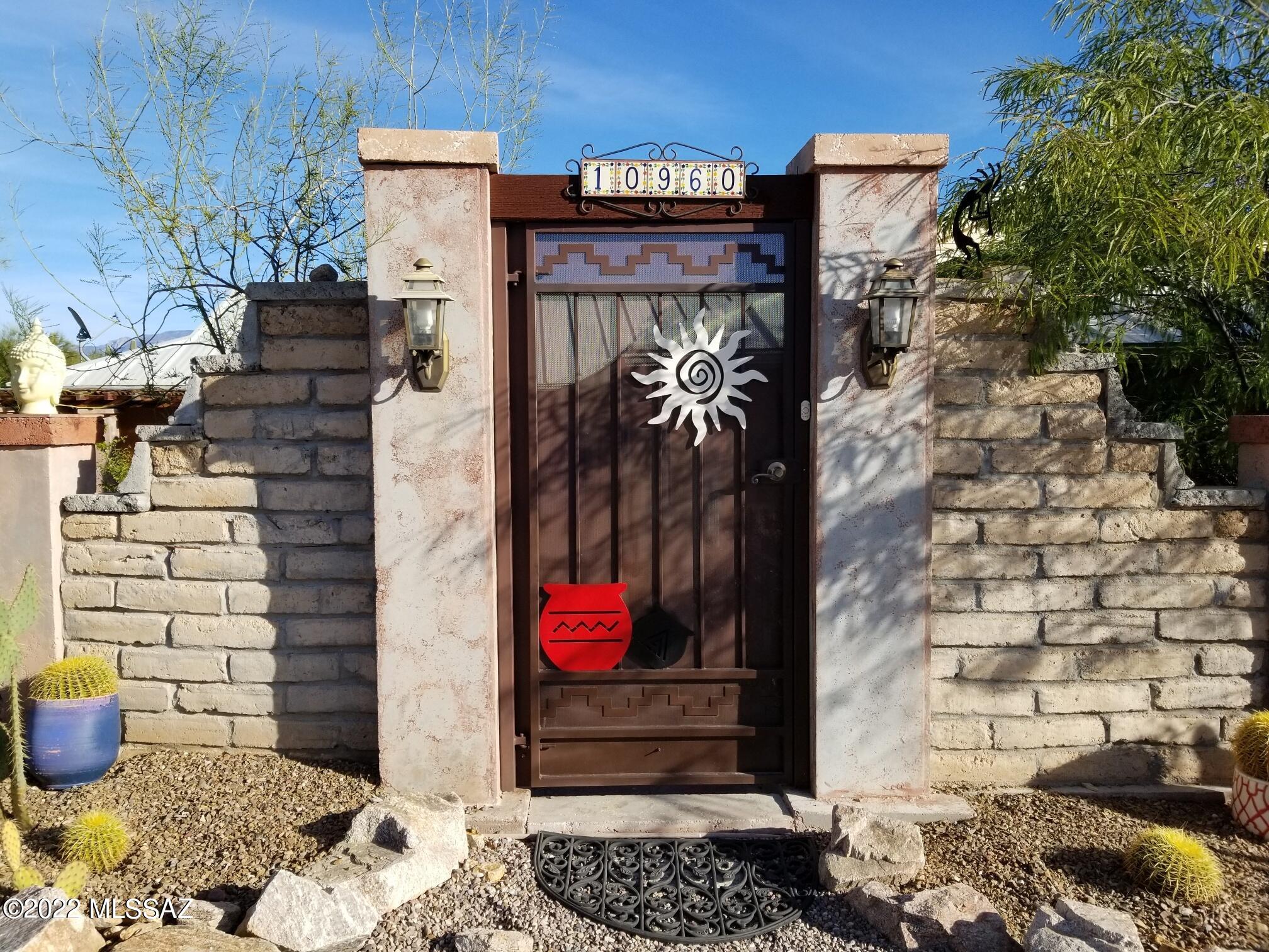 Artistic home built 1995 with 4 bedrooms, 2 baths, and detached 2-car garage. One story  w/1870 sf on 1+ acre fully fenced. Easy Northwest & I-10 commute access. Updated kitchen appliances with hand carved Pecan cabinets & glass pendants. Gorgeous gated courtyard with wrought-iron fence. Storage buildings with electrical outlets, Studio w/wall AC has multiple uses as home office, etc. East backyard with extended covered patio the length of home. Private patio off owner's suite w/Pergola's with SPA to unwind. NO HOA with room for the RV motorhome, boats, and desert views to admire. Many ''Green'' features such as owned Solar (Avg $24-50/mo), newer HVAC unit, metal roofs, and tankless water heater. See documents for Seller Improvements List & Disclosures. A very special place to call home!