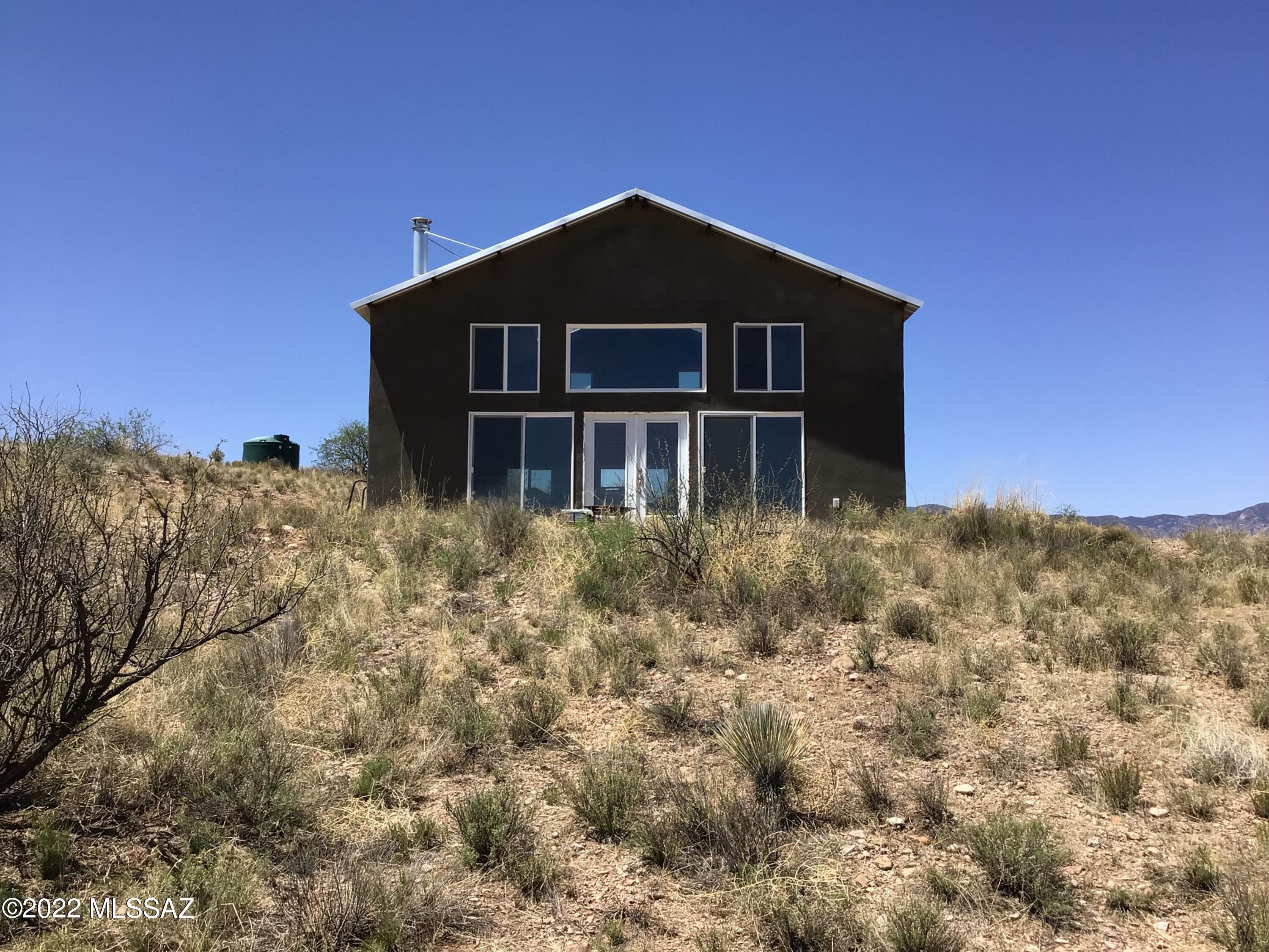 36.57 acres with a large open concept studio that has a loft within the majestic Eureka Spring Ranch.  Beautiful location to getaway and do some 4-wheeling, hunting, hiking, stargazing and just plain relaxing.  Enjoy the panoramic views outside while sitting atop your own hill or from in front of the inside wood burning fireplace looking out through the all-walls sliding glass doors.  This corner lot has a water tank storage to hold hauled water hooked to house that has a kitchen sink & bathroom with walk-in shower.  Outside plug can be hooked up to the generator to run electricity, but the hot water heater is not hooked up. Access loft by ladder, but there is plenty of room to add a stairway.  Come and complete what was started and make it your own. GPS: 32.620787,-110.1323