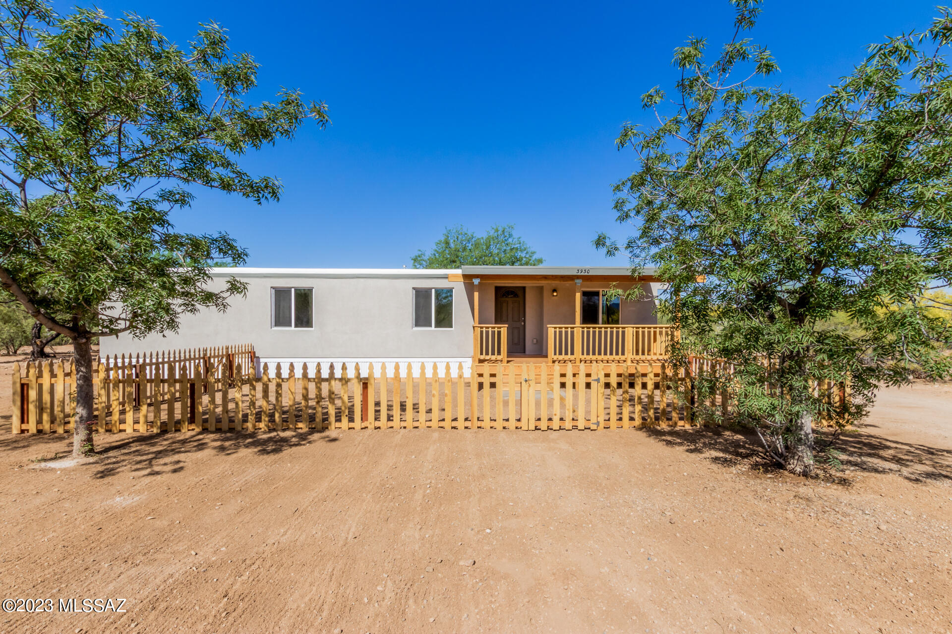 Beautifully updated manufactured home located near Tucson Mountain Park on 0.96 acres! A peaceful setting showcasing mountain views, lovely wood fencing, and natural desert vegetation will greet you as you arrive.  Inside, you'll find an open floor plan living and dining area, neutral paint, recessed lighting, and handsome LVT flooring for easy maintenance. This 3-bedroom home has been remodeled with new plumbing, new electrical, new decking, recoated roof, new double pane windows, new doors, and two beautiful bathrooms with designer tile. Spotless kitchen with white shaker cabinets and brand-new SS appliances (to be installed with accepted offer). Nice master bedroom boasting a walk-in closet and an ensuite. New paint inside and out, stucco exterior and a super cold new AC. Charming front porch provides an ideal spot for sipping your morning coffee, enjoying a good book, or simply taking in the wonderful mountain vistas. Welcome home!