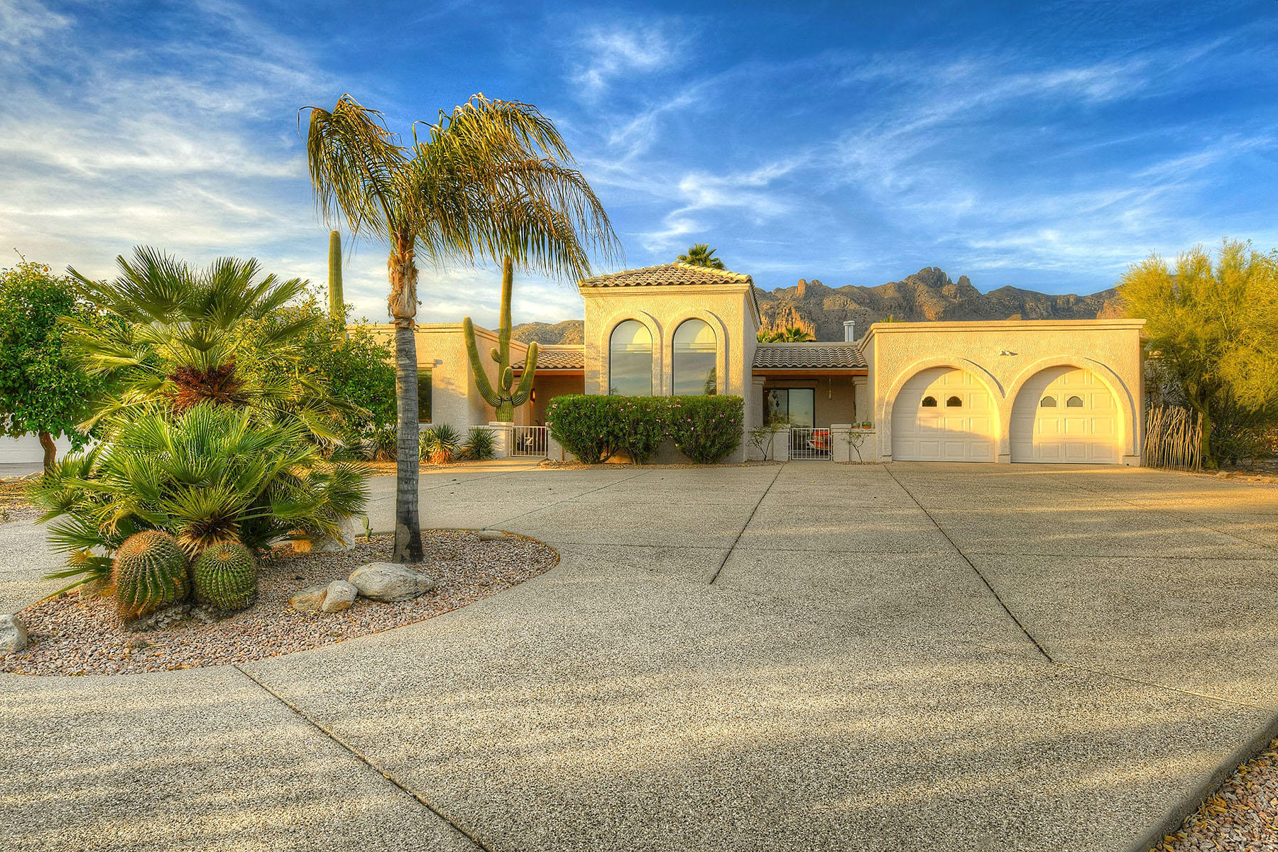 Sellers will accept or counter offers from $959,000 - $1,029,000.  This custom 3,170 sq. ft. contemporary by Gary Almli is nestled high in the foothills and offers sweeping Catalina Mountains & city views. Highlights of the 5-bedroom, 3½-bath home include long exposed aggregate driveway, a split bedroom floor plan, a grand foyer with numerous arches, a generous living room with a soaring coved ceiling, and a formal dining room. The spacious family room features a beamed & planked ceiling with corbels and a cozy fireplace. The fabulous kitchen, open to the family room, provides a gas cooktop, a breakfast area, alder cabinetry and a large center island. The gracious master suite offers access to a private covered patio, a walk-in closet, a spa tub and dual vanities. The three east-wing bedrooms have their own activity room and include a guest room/nanny suite with en-suite bath & a separate entrance  perfect for families and work-at-home. Enjoy the beautiful outdoor living areas including a beamed & planked covered patio, a sparkling pool/spa, a turf area, professionally landscaped grounds, and sweeping Catalina Mountain views! Additional features include a total of 4 covered patios (545 sq. ft. of porch area), a 567 sq. ft. 2-car garage with 2 storage areas and overhead storage rack, 7 ceiling fans, 11 skylights, lots of light, mature vegetation, citrus trees, and many upgrades. The home is within walking distance of La Encantada Mall, Manzanita Elementary School, shopping and restaurants. District #16 Schools.