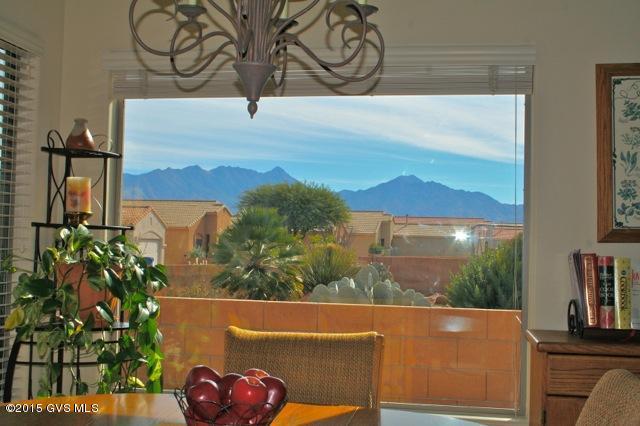 Magnificent Santa Rita views from the living areas and back patio in this lovely 3 BR plus den model in the Legends! This home embraces the GREAT ROOM concept with its large and open living, dining and kitchen areas. 18 inch earth tone ceramic tile flows throughout and is complimented with custom interior paint, elegant light fixtures and recessed lighting. The kitchen is also done in warm desert tones and features a gas range, tile backsplash, black appliances and breakfast bar. The dining area has large windows framing those captivating views-your dinner guests will never want to leave! The living area is accented with beautiful double French doors leading out onto the covered patio featuring brick pavers, a built-in viewing bench, and a meticulously maintained desert landscape.  Your master suite is luxurious with executive height counters, double sinks, walk-in shower, a large walk-in closet, and breathtaking views of the mountains! The guest suite has its own bath and the third bedroom can easily be transformed into a den. Stunning mature cacti, a tile roof and an arched entryway make the outside of this home as enchanting as the interior! A warm and inviting ambience, impeccable taste and stunning views all combine to make this home one of those truly special finds!