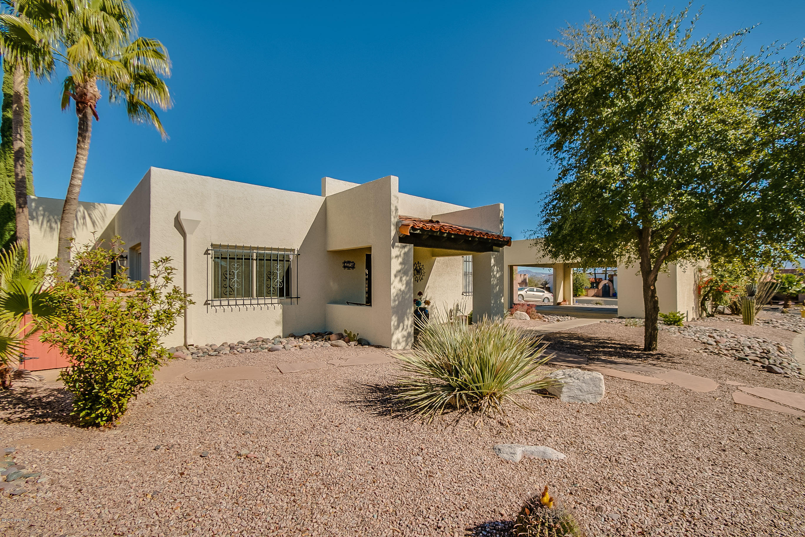 This gem offers 1469 sq.' of living space with two bedrooms, two baths and a spacious living area. The home has all tile floors, stainless steel appliances and four sliding glass doors that provide easy access to the beautifully landscaped yard. The outdoor space includes multiple covered patio spaces with lovely Santa Rita mountain views and a hot tub. The home is in the popular Desert Hills 5 community, has been very well maintained and is move in ready making it a perfect desert paradise. The laundry closet is spacious with a convenient utility sink. The large two-car carport has potential for enclosure. Most of the furniture and contents are available via a separate bill of sale.