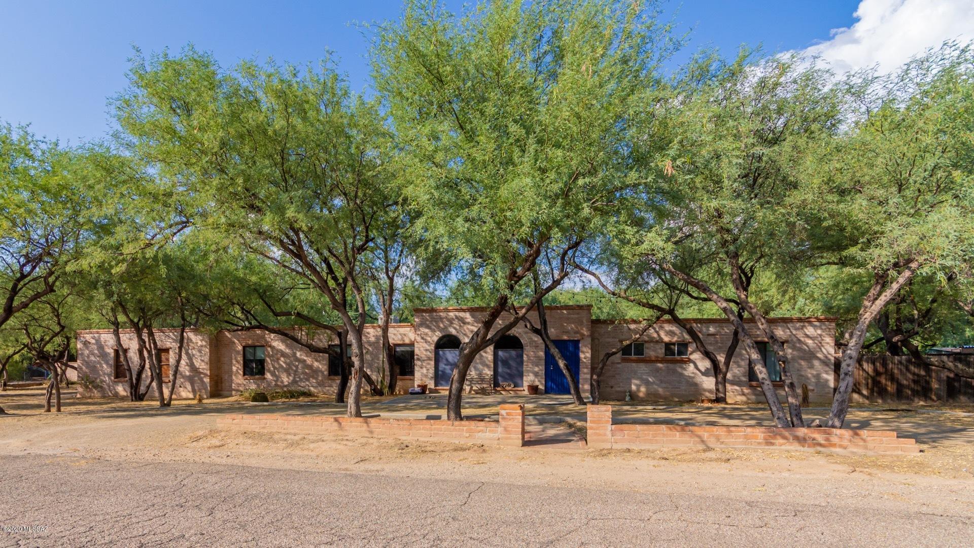 Nestled under mature mesquite trees, discover this 4-bedroom adobe home in an enchanting neighborhood just off the Tanque Verde Creek. The backyard is an ideal setting for entertaining with a NEW immaculate pool, covered patio, and artificial turf landscaping (all new as of 2017). Inside, you'll find elegant wood wood beam ceilings, a cozy brick fireplace, and beautiful modern flooring. Minutes from shopping, restaurants, Udall park, and the Rillito River Walk.