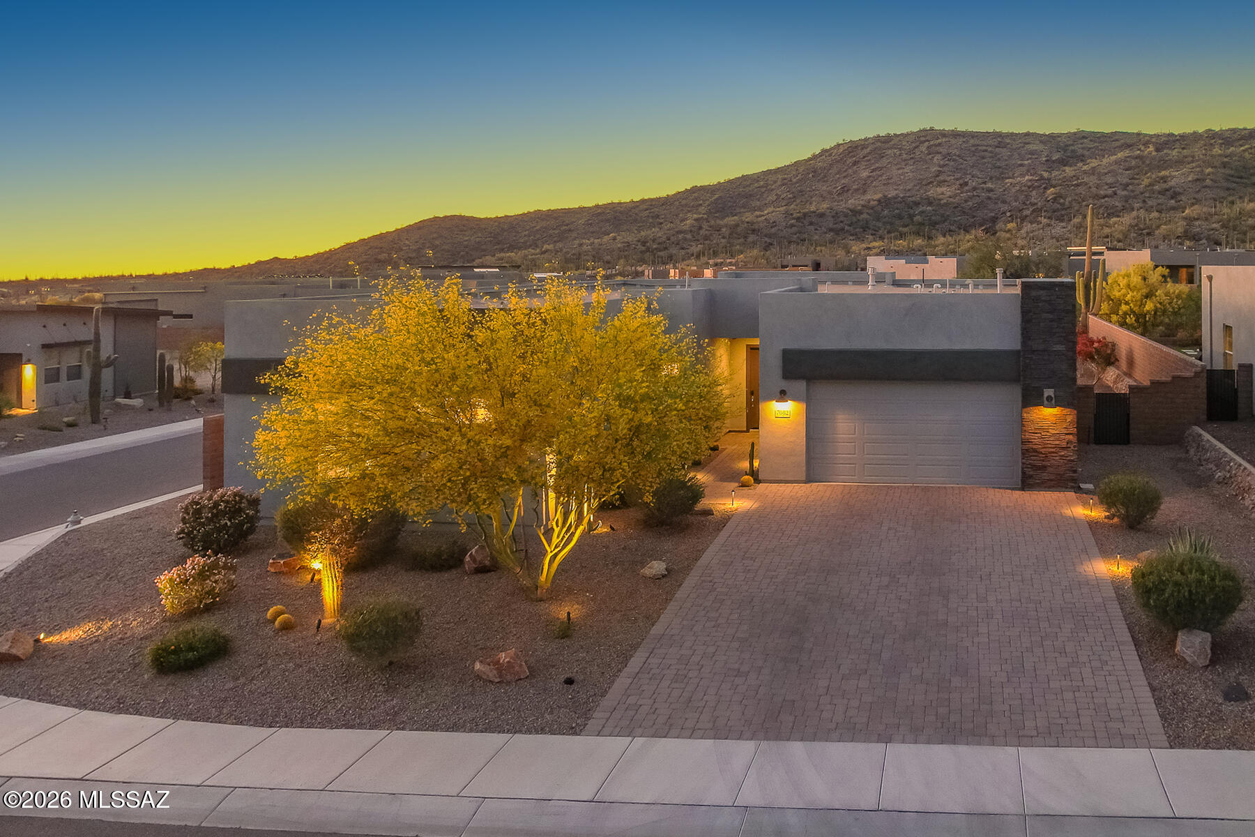 Experience stunning contemporary design in the highly sought-after gated community of Boulder Bridge Pass III at Dove Mountain! This ''better-than-new'' estate (4BR/3.5BA 3017sqft), built in 2022, is perfectly situated on a premium corner lot with no neighbors behind you-offering unparalleled privacy and forever views of the open desert and Tortolita Mountains. From the moment you enter the light-filled foyer, you're greeted by dramatic window walls that seamlessly blur the lines between indoor comfort and outdoor beauty. The expansive Great Room serves as the home's centerpiece, anchored by a chic gas fireplace with designer tile surround, a perfect focal point for sophisticated entertaining or quiet evenings in. The chef's kitchen is a masterpiece of modern luxury, featuring professional grade stainless steel appliances, a generous island, and quartz countertops that will delight any culinary enthusiast. Retreat to the primary suite where large picture windows frame sunset views, leading to a spa-like bathroom complete with an oversized walk-in shower and dual vanities. Outdoor living is truly elevated here. The professionally landscaped backyard borders a quiet common area, providing a serene backdrop for the covered patio. There is even plenty of room to add a custom pool! Best of all, membership to The Golf Club at Dove Mountain is part of owning this property, giving you immediate access to world-class golf, fitness facilities, and exclusive social events.