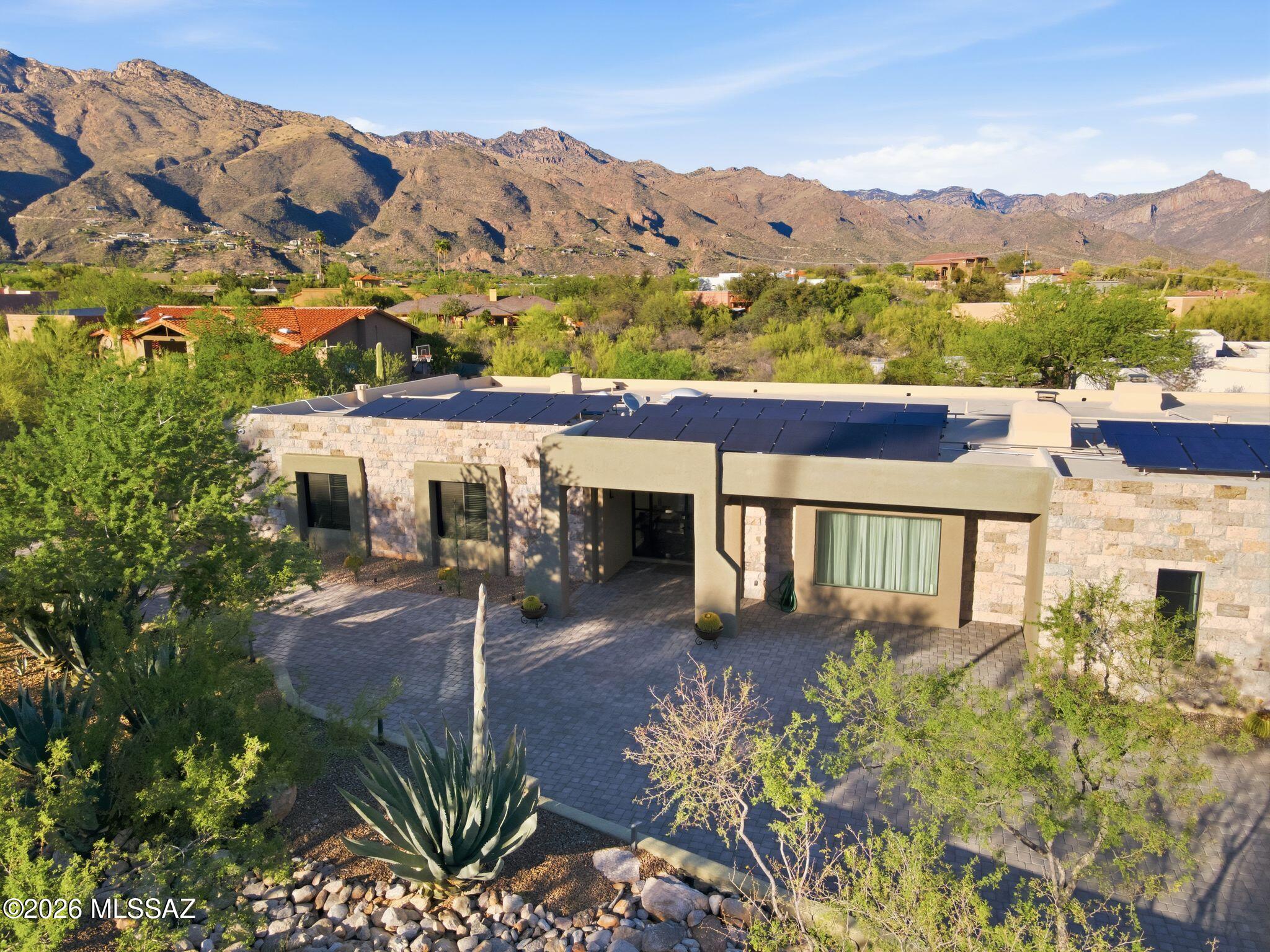 Where Architectural Flair meets Beauty and Serenity. A Modern Contemporary design by Ron Robinette with privacy, views of the Catalina Mountains.  A Chef's Kitchen with Italian Appliances, a cascading quartz water fall design Breakfast Bar / Pre Area, as the center piece of the Kitchen. A luscious and luxurious Primary Master Bath & Suite, Fireplace and views, three spacious Guest Bedrooms with one offering an ensuite, perfect for Guests. Energy efficiency offers 42 elite solar panels w/30 yr warranty, the additional &  versatile Bonus/Media/Den area offers so much benefit & the generous 3 Car Garage with EV Hook up adds value.  An effortless transition from House to Desk to Back Yard sanctuary.