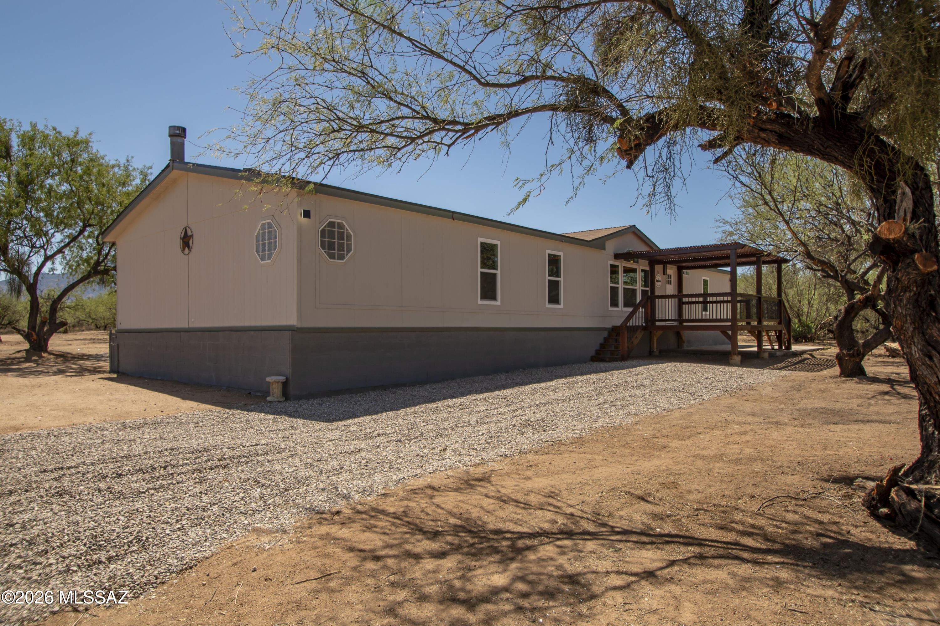Enjoy peaceful country living on over 5 acres with breathtaking views of Elephant Head and the surrounding mountains. This beautifully renovated 2,240 sq. ft. manufactured home features a new roof, new kitchen with cabinetry, countertops and appliances, remodeled bathrooms, new laminate flooring, new dual-pane windows, and a new heating and cooling system. The wood-burning fireplace adds warmth and charm. With plenty of room for horses, RVs, or outdoor recreation, this property offers endless possibilities. No HOA, septic system, and water is provided through a private water company with an unmetered shared well. Conveniently located with easy access to I-19, Green Valley, and Tucson.