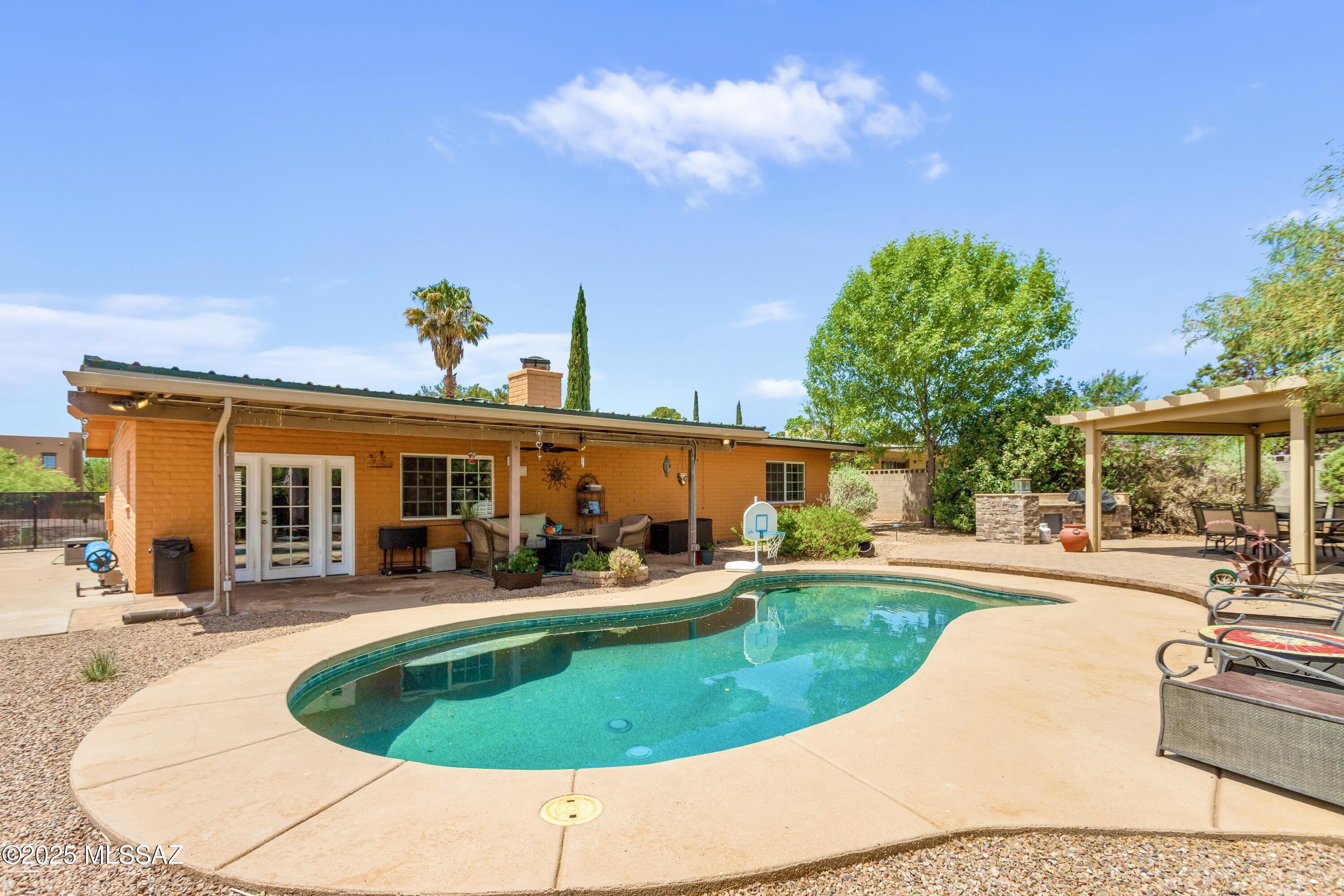 Stylishly Updated 4-Bedroom Home with Private Pool & Outdoor Oasis! This beautiful 4 bedroom, 2 bathroom home with a 2-car garage offers the perfect blend of comfort, style, and outdoor living. Inside, enjoy an inviting living area with a cozy wood-burning fireplace, a spacious kitchen and updated bathrooms,durable tile & laminate flooring throughout, with elegant custom wood shutters. Step outside to your private backyard retreat featuring a sparkling Pebble Tec pool, a paver stone patio, a built-in outdoor kitchen, a charming pergola, and a durable metal roof overhead. Whether you're relaxing poolside or entertaining guests by the grill, this home is designed for effortless Arizona living.