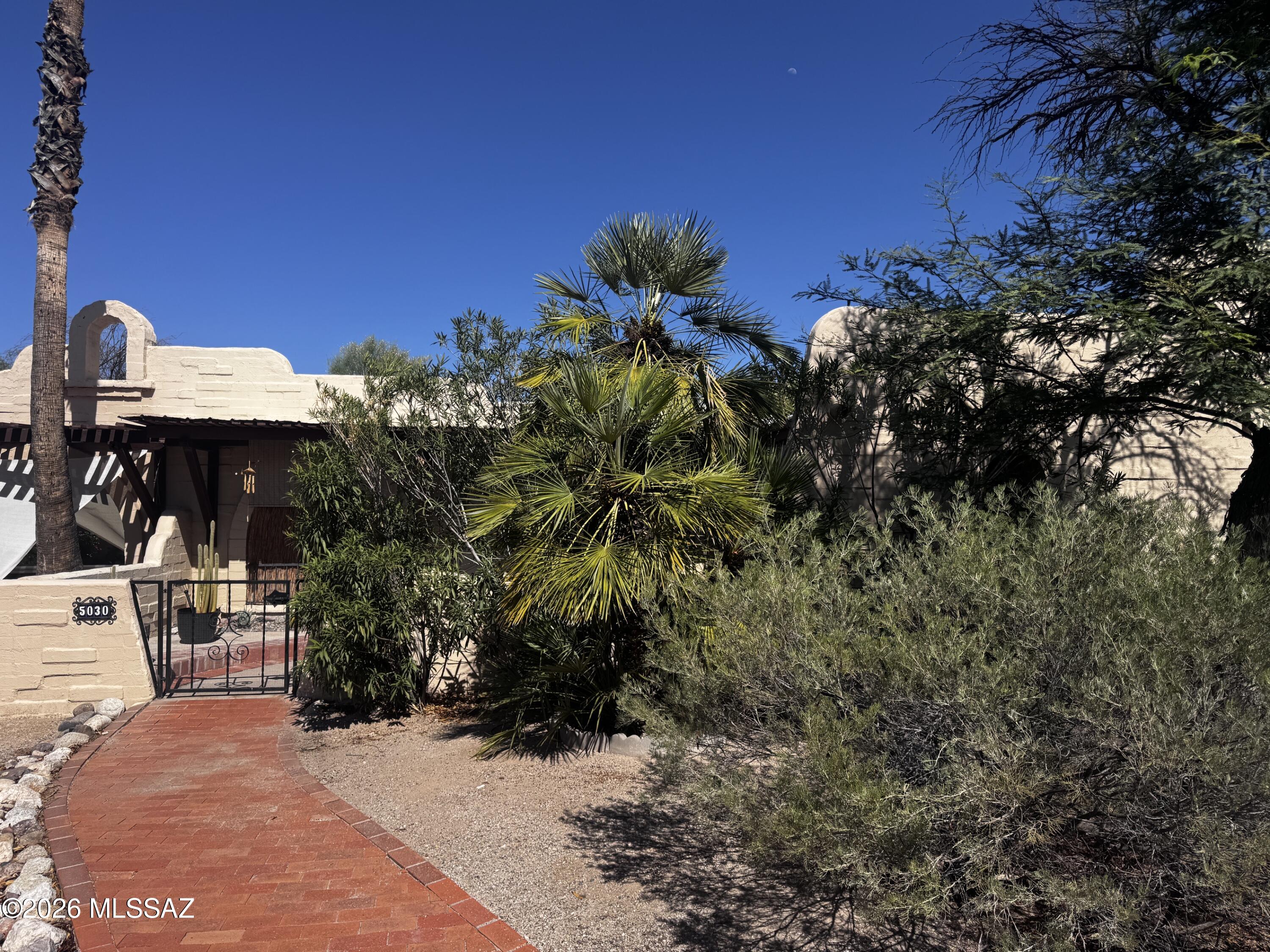 Tastefully renovated Southwest Pueblo-style townhome in a convenient North/Central location near Oracle and River. This desirable end unit offers abundant natural light from skylights and solar tubes, along with three sets of French doors opening to multiple private patio areas. The inviting interior features tile flooring throughout, a family room with gas fireplace, and a stylish kitchen with updated cabinetry, countertops, newer appliances, separate cooktop and oven, and pantry storage. Two spacious bedrooms include updated French doors and sidelights. The primary bath features a jetted garden tub, while the guest bath offers a walk-in shower. Additional updates include modern light fixtures, faucets, and toilets. The laundry room includes a full-size washer and dryer, plus a full-size washer and dryer, plus a full-size freezer. Energy-efficient features include a 4kW solar system, dual-pane windows, water softener, and a 220V EV charger in the garage. A/C and water heater replaced in 2019; roof work and termite treatment completed in 2021.