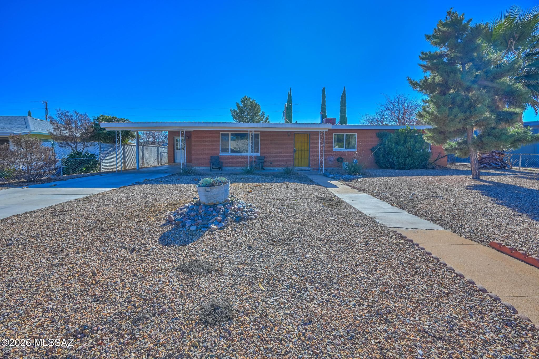 LOOK HERE! This affordably priced 3-bdrm 1668 SF home offers a great opportunity in a desirable mid-town location near Ft Huachuca. The ample living area offers wood-laminate flooring and the kitchen is perfect for cooking & baking. Corian countertops, stainless appliances, an electirc cooktop, a breakfast bar, cabinet & counter space, and in-kitchen dining. The primary bedroom includes an en-suite bath with a walk-in shower. Two additional bedrooms with a nearby full guest bath. There's also a spacious indoor laundry room for added convenience and storage. Outside, enjoy a generous backyard with grass, covered patio, and storage shed. A durable metal roof, carport, driveway parking, and covered entry complete this value-packed home ready for your personal touches. Come see today!