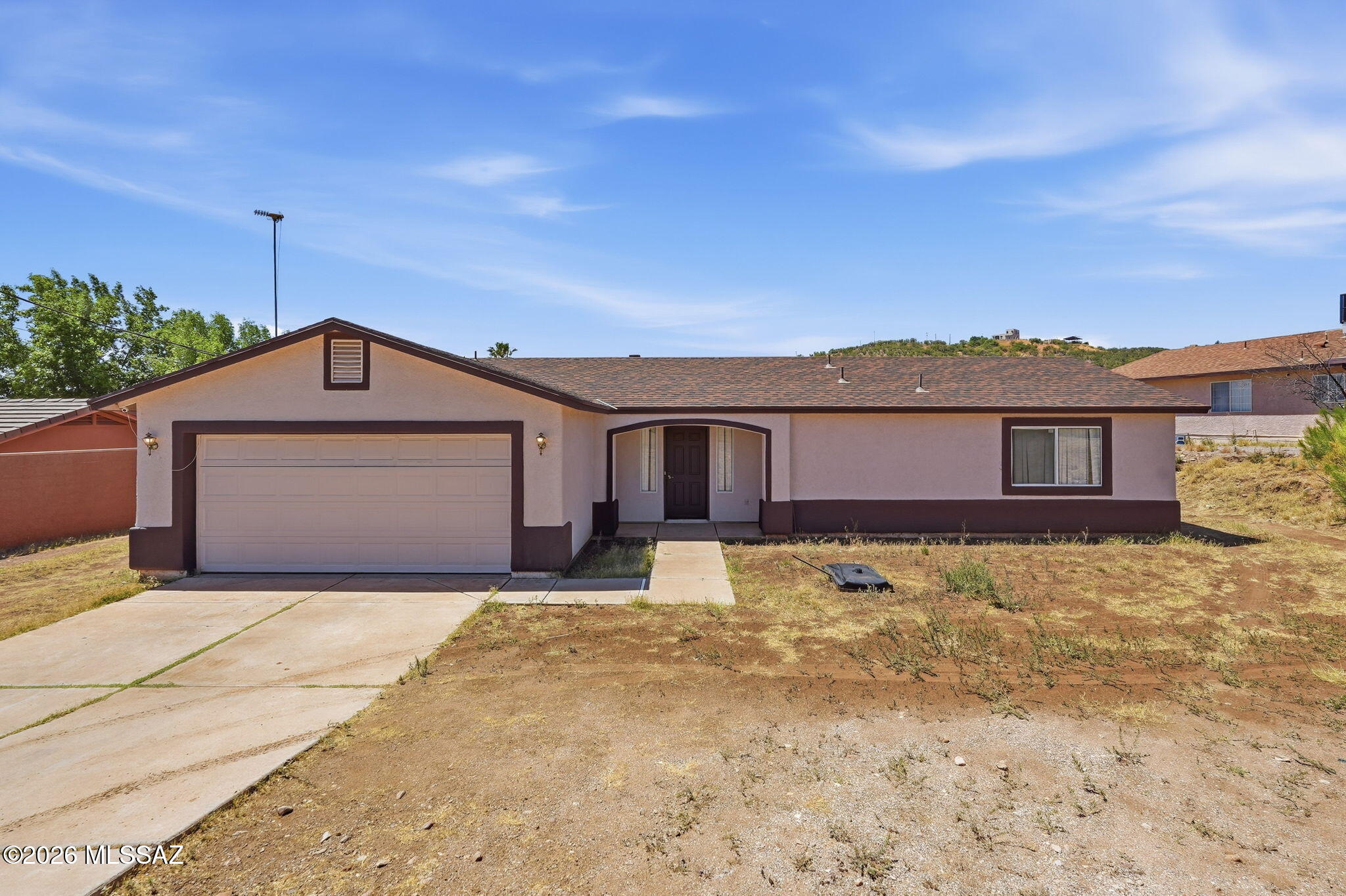 Welcome to this charming 3 bedroom, 2 bathroom home in Rio Rico featuring beautiful mountain views and a functional single-story layout. The home offers a spacious living area with tile flooring and a cozy fireplace. The kitchen includes ample cabinet space, a breakfast bar, and a dining area with access to the backyard. Enjoy a comfortable primary suite, good-sized bedrooms, and a 2-car garage. The outdoor space offers room to personalize and take in the peaceful surrounding views. A great opportunity for buyers looking for space, comfort, and potential in Rio Rico.