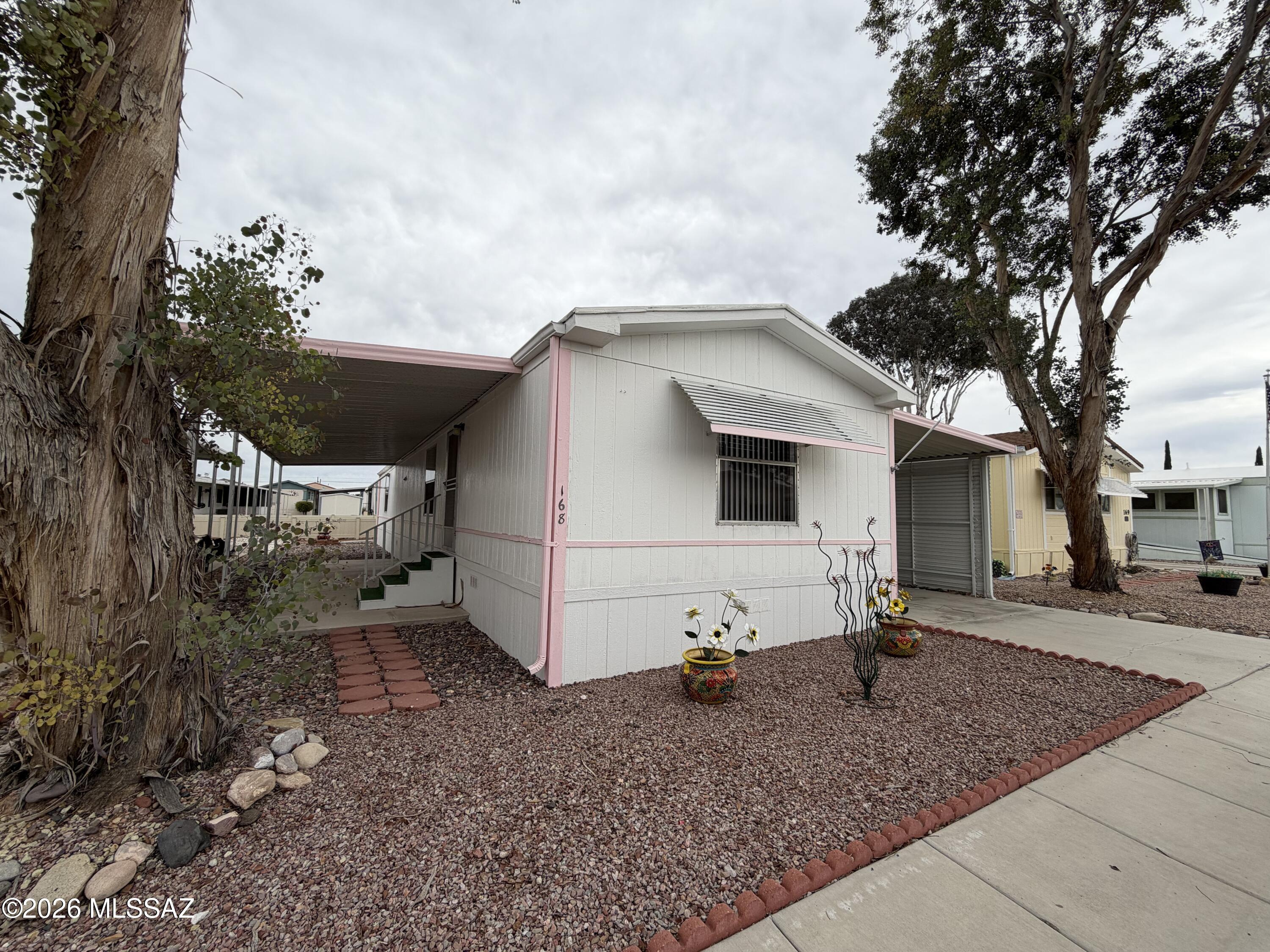 This 2 bed/ 2 bath home is in the gated community of  Trails West Resort community, offering low maintenance living and access to fantastic amenities. This is a Vibrant active adult community.  This 1,056 sq ft residence features a bright great room, skylights, a split bedroom layout, and a spacious kitchen with an island, pantry cabinet, electric range, and refrigerator. The primary suite includes a double vanity, walk-in shower  and walk-in closet, while the second bath offers a shower/tub combo. Outside, find low-care landscaping, a covered patio, two-car carport, and a large storage shed. Community perks include a pool, spa, clubhouse, rec center, shuffleboard, exercise facilities, and secure gated entry.