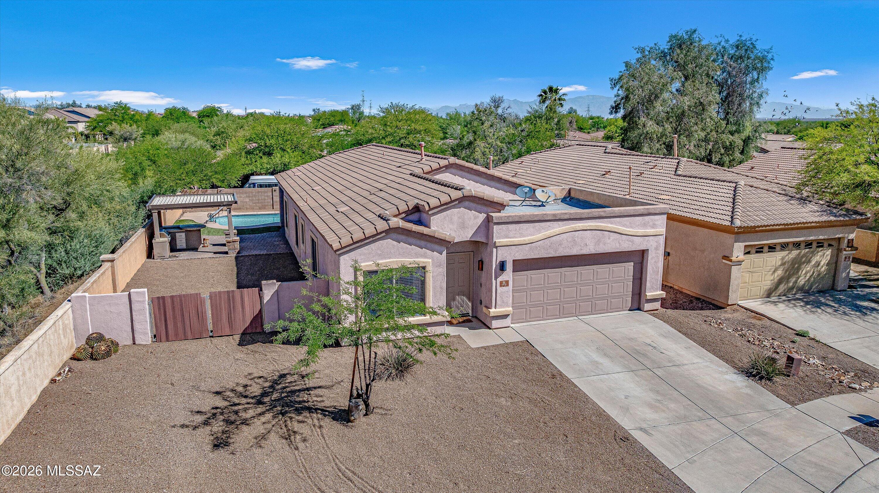 This single-story Sahuarita residence in Presidio Del Sol features 1,872 square feet of split-plan living with plenty of storage and no wasted space! You'll find ceramic tile flooring and a neutral palette throughout, with a large central kitchen island and separate living and dining areas. The private pool and covered porch are featured on the large  ~.19-acre lot with double gate access. Inside, a secluded primary suite offers walkout patio and pool access, a soaking tub, shower and dual vanities. The property sits near Presidio Lake, Anza Trail School, and Walden Grove High. Access to The Loop and local trails is immediate.