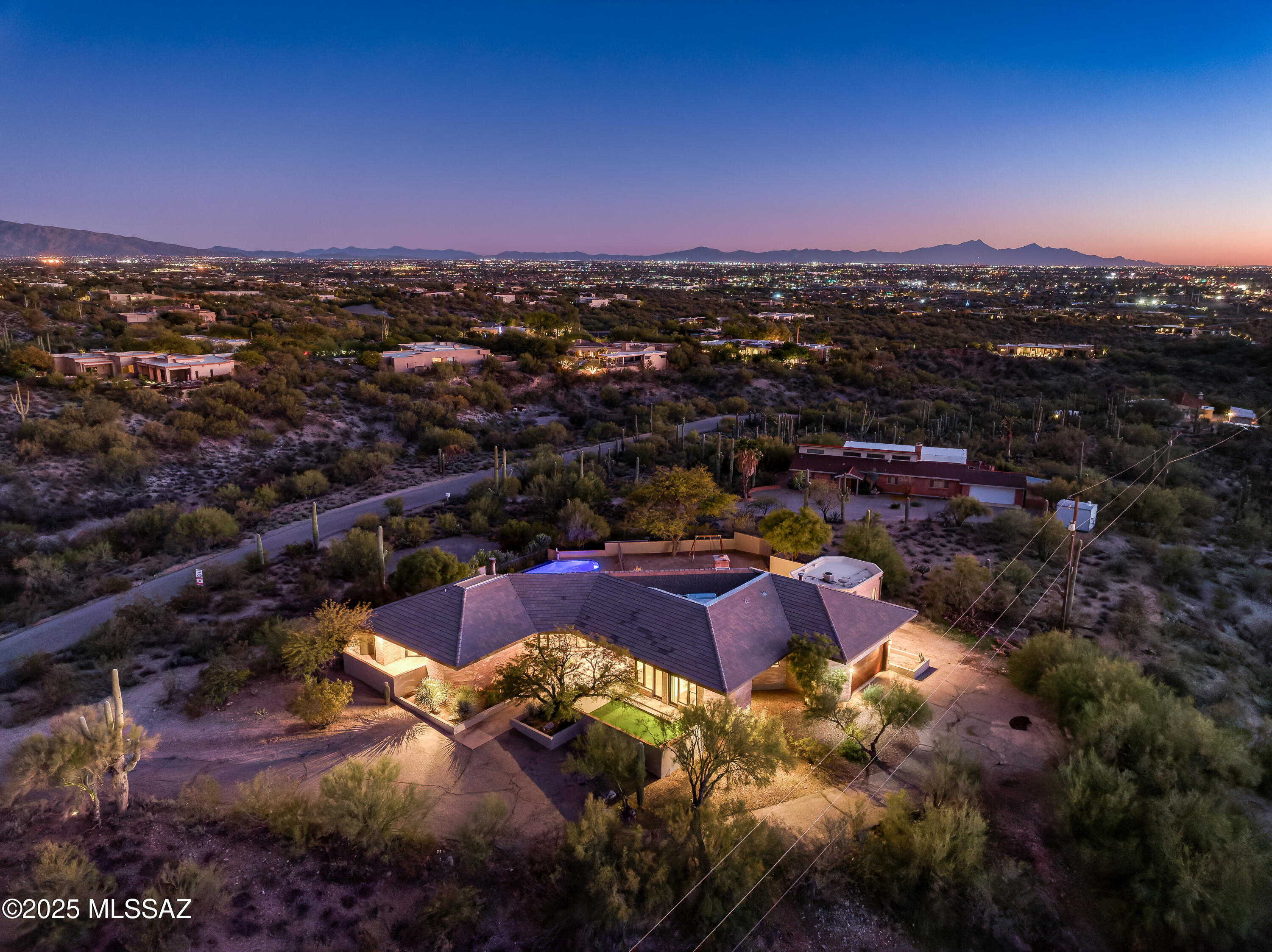 Positioned on expansive land in the heart of the Catalina Foothills, 4740 N Hacienda Del Sol Road offers a rare blend of refined luxury, thoughtful modernization, and sweeping desert views—with voluntary HOA and no CCR's. This exceptional Foothills residence captures the essence of upscale Tucson living, combining privacy, space, and proximity to the area's most sought-after amenities, including world-class dining, shopping, golf, hiking trails, and renowned schools. The home has undergone significant upgrades, with the kitchen and bathrooms fully remodeled to meet modern luxury standards. Designed as both a showpiece and a functional gathering space, the chef's kitchen features granite countertops, a custom breakfast bar, and a premium Viking appliance suite, including a separate refrigerator and freezer, dual ovens, and professional-grade performance ideal for entertaining on any scale. The open floor plan allows the kitchen to flow seamlessly into the main living areas, creating an inviting environment filled with natural light from newly replaced windows throughout the home.

An abundance of natural light highlights the engineered wood flooring, newly replaced in summer 2025, and enhances the home's warm, cohesive aesthetic. Architectural character and comfort are further elevated by two wood-burning fireplaces, which add timeless charm and create inviting focal points in the living spaces.

The primary suite is a private retreat, offering a spa-inspired bathroom finished with luxurious Carrara marble, delivering an elegant, resort-quality experience. Secondary bathrooms have also been tastefully remodeled with high-end finishes that maintain consistency throughout the home.

A highly flexible floor plan includes a fourth bedroom with a separate entrance, making it ideal for guest quarters, multigenerational living, a private office, or studio space--an increasingly desirable feature in Catalina Foothills properties.

Outdoor living is a defining element of this residence. The updated backyard is designed for true Arizona resort-style enjoyment, featuring a sparkling pool, outdoor kitchen, and generous entertaining areas surrounded by mature landscaping. The expansive lot enhances privacy while providing beautiful Foothills views and a strong connection to the surrounding desert environment--perfect for enjoying Tucson's year-round climate.

With its open, light-filled interior, luxury finishes, dual wood-burning fireplaces, expansive land, scenic views, and premier Catalina Foothills location, 4740 N Hacienda Del Sol Road represents a rare opportunity to own a turnkey luxury property that balances elegance, comfort, and lifestyle in one of Tucson's most prestigious settings.