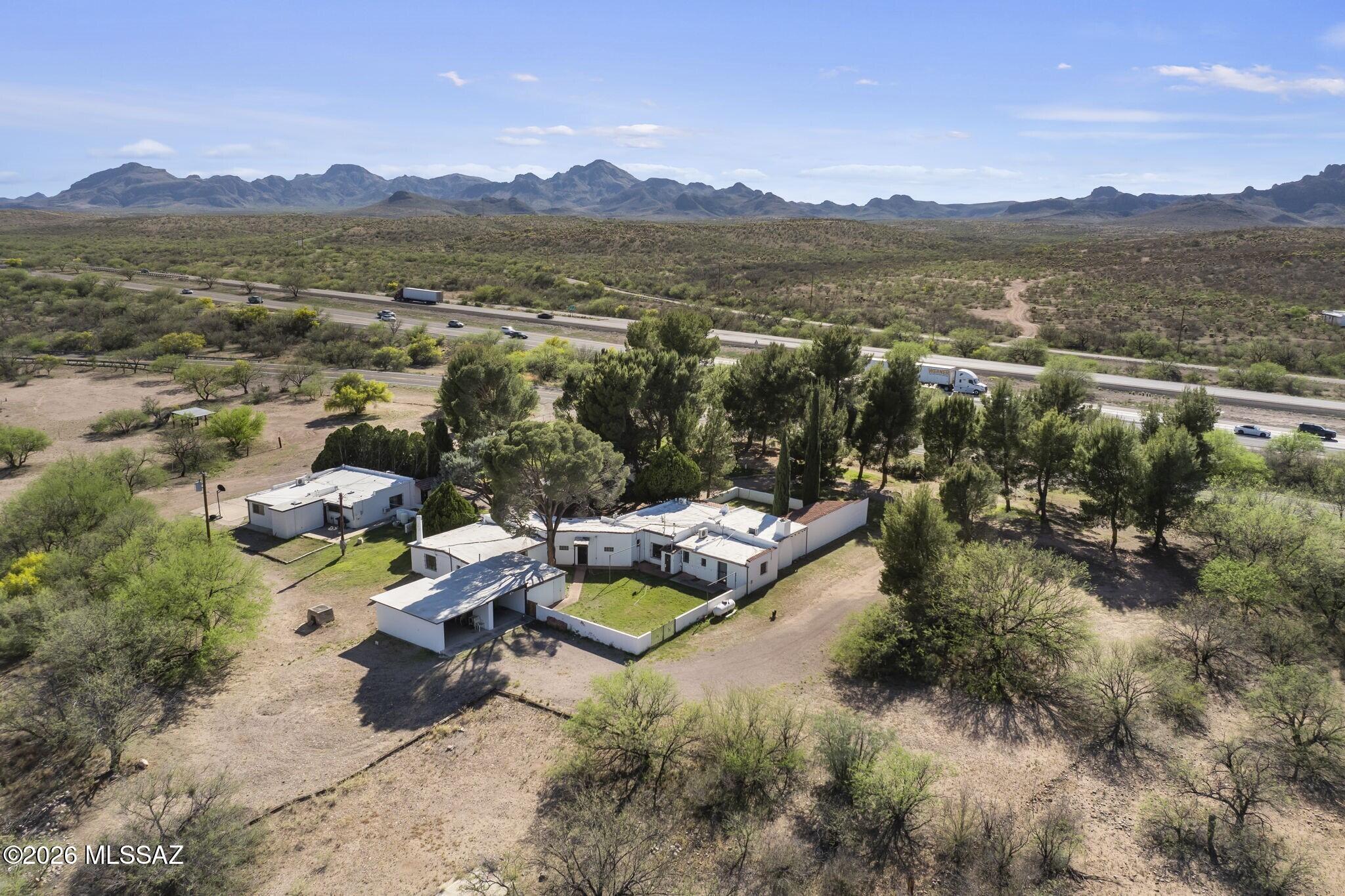 Escape the ordinary in this magical historic ranch, built in 1926 and set on 8.96 acres, offering a rare blend of heritage, space and privacy. Nestled against unobstructed panoramic views of the Santa Rita Mountains, it's waiting for you to add to its legacy with no HOA to hinder your vision. Horses are welcome here, and there's room to roam. Walled backyard with grass lawn and multiple terraces offers plenty of livable outdoor space. Main residence offers four bedrooms and three baths, charming gathering room with seated bar, plus exposed beam ceilings, multiple fireplaces and vintage details. Separate casita expands the possibilities for multi-generational households, frequent guests or income-producing rental property with two bedrooms, two baths, den, plus a light-infused Arizona room.