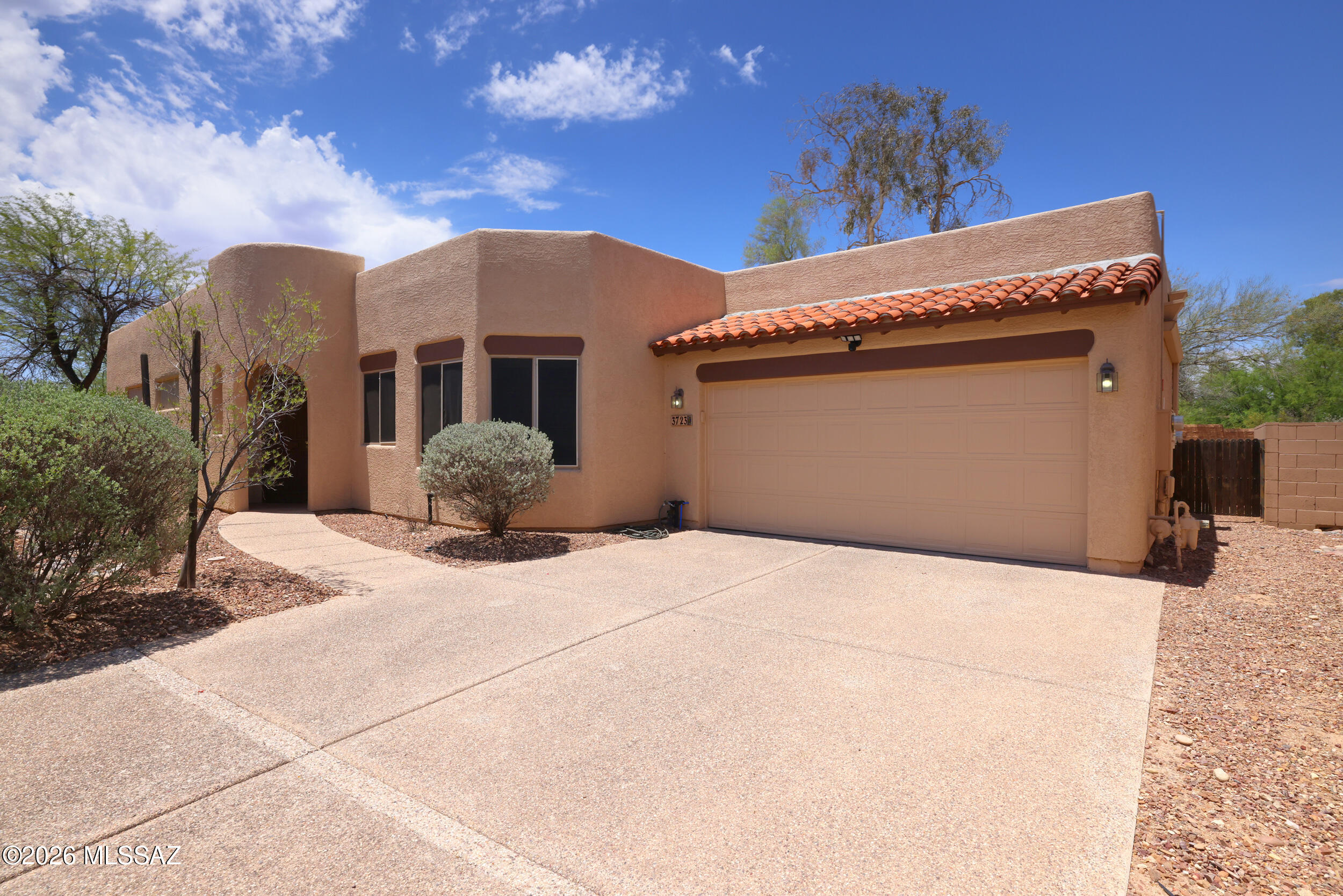 Phenomenal location minutes from U of A, Banner Hospital & shopping, sits this special home. Nestled at the end of a cul-de-sac, in a small community offering 24-hour video surveillance, sidewalks and a community pool.  This home itself is set off by gorgeous scored & colored concrete floors.  An abundance of windows & glass doors create light-filled living.  A center island kitchen features SS appliances, gas cooking, plus a pantry.  The spacious master suite boasts sliders to the rear yard, walk in closet and bathroom w/dual vanity sinks, separate shower and large garden tub.  In the rear yard enjoy a large covered patio surrounded by artificial grass & lush mature Mesquite for additional privacy and shade.