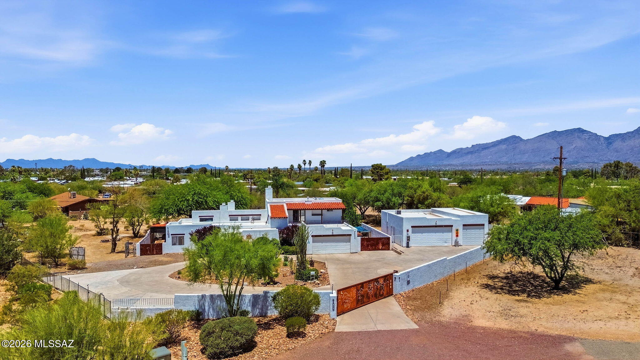 Rare opportunities like this are hard to find. Nestled on over an acre with no HOA, this custom East Tucson home is privately tucked behind a block wall with an electric gate and welcomed by a fully paved circular concrete driveway. The property features an attached 2-car garage plus a detached framed stucco garage with room for additional vehicles, making it ideal for car enthusiasts, RVs, or a workshop. Enjoy a sparkling pool, mature landscaping, and plenty of space to entertain. The expansive lot also offers room to build a private casita or ADU for guests, multigenerational living, or future value. A unique blend of privacy, functionality, and convenience just minutes from shopping, dining, and everyday amenities. Inside, you'll find a thoughtfully designed floor plan offering 2,776 square feet with 3 spacious bedrooms and 3 bathrooms. The home features generous living and dining areas filled with natural light, a well-appointed kitchen with abundant cabinetry and workspace, and a comfortable primary suite designed for everyday living. Large windows frame views of the surrounding landscape while creating a seamless connection between the indoor and outdoor living spaces. With timeless finishes, spacious rooms, and a layout that balances comfort and functionality, this home is ready to enjoy while offering the opportunity to personalize and make it your own.