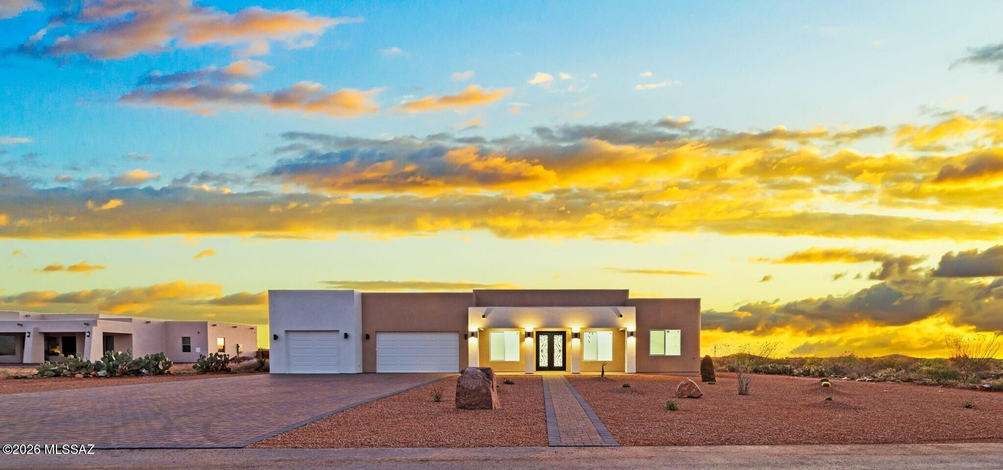 Seller will accept or counter offers between $649,000 and $665,000. Introducing a stunning expression of modern desert luxury, this meticulously designed four-bedroom, three-bath residence is perfectly positioned on a sprawling .91-acre homesite within the desirable Windmill Ridge at Mountain View Ranch Community. From the moment you arrive, the home makes a striking first impression. A set of dramatic double metal doors welcomes you inside, where soaring 12-foot ceilings, expansive walls of glass, and sleek 24'' x 48'' porcelain tile flooring create a light-filled, sophisticated interior that seamlessly blends style and function. The chef's kitchen is both functional and modern, featuring stainless steel appliances, a spacious center island with a breakfast bar and designer pendant lighting highlights the oversized breakfast bar. Custom quality cabinetry with crown molding is paired with stunning quartzite countertops, celebrated for their timeless elegance and durability. The gas range and convenient pot filler elevate everyday cooking and entertaining.
The spacious owner's suite offers a peaceful retreat, thoughtfully designed with comfort in mind. A large picture window frames views of the backyard, while the spa-inspired bath invites relaxation with a fully tiled walk-in shower featuring a rain head and built-in seating, a separate soaking tub, and a striking quartzite dual vanity complemented by an illuminated mirror with integrated features. A desirable split-bedroom floor plan ensures privacy, with three additional generously sized bedrooms and two beautifully appointed bathrooms, ideal for family or guests. The well-designed laundry room includes built-in cabinetry and a utility sink, while the expansive three-car garage features 11-foot ceilings and is pre-wired with 220V for EV charging.
Outdoors, the possibilities are endless. Aesthetically designed paver finishes and an iron RV gate provide both beauty and functionality, while the expansive backyard offers ample space to create your own resort-style retreat complete with room for a pool, outdoor kitchen, and multiple entertaining areas to fully embrace year-round Arizona living. Windmill Ridge is a picturesque neighborhood with sweeping mountain views, abundant open space, and the convenience of nearby shopping, dining, and quick access to I-10 all within the highly regarded Vail School District.