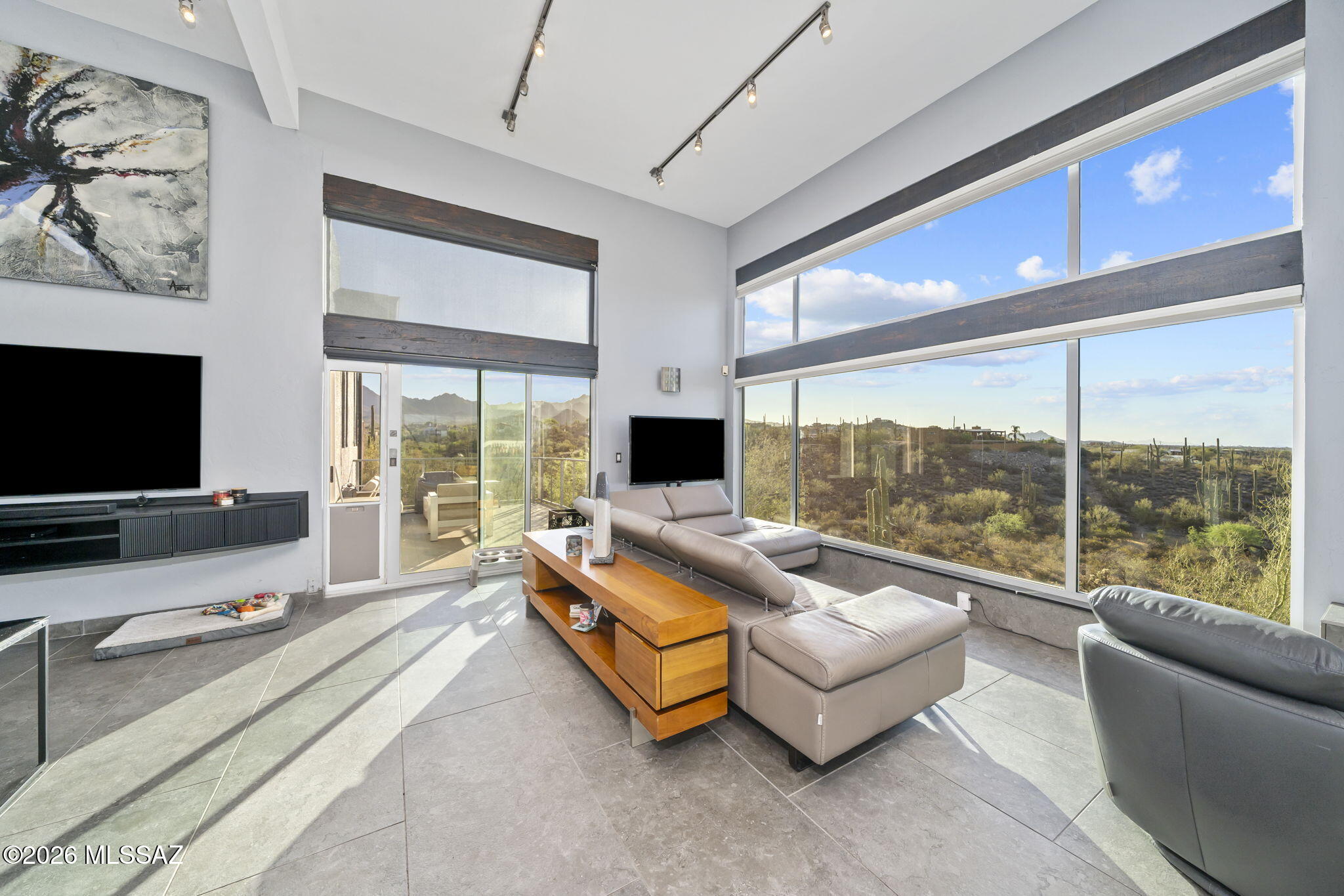 Thoughtfully updated residence featuring refined desert-modern design with panoramic views. Kitchen offers quartz countertops, matching quartz backsplash & a clean, contemporary finish. Multiple skylights with a cathedral ceiling in the great room fill the home with natural light and enhance the architectural flow. Living area showcases a 13-ft floor-to-ceiling custom tile surround framing a 58-inch three-sided Napoleon electric fireplace, updated bathrooms include custom tile, acrylic cabinetry, and quartz counters. Oversized two-car garage features a custom glass door. Close proximity to hiking & biking in Tucson Mountain Park and Saguaro National Park West; 15 minutes to Downtown and University of Arizona campus. Ideal for wildlife viewing with frequent desert species sightings.
