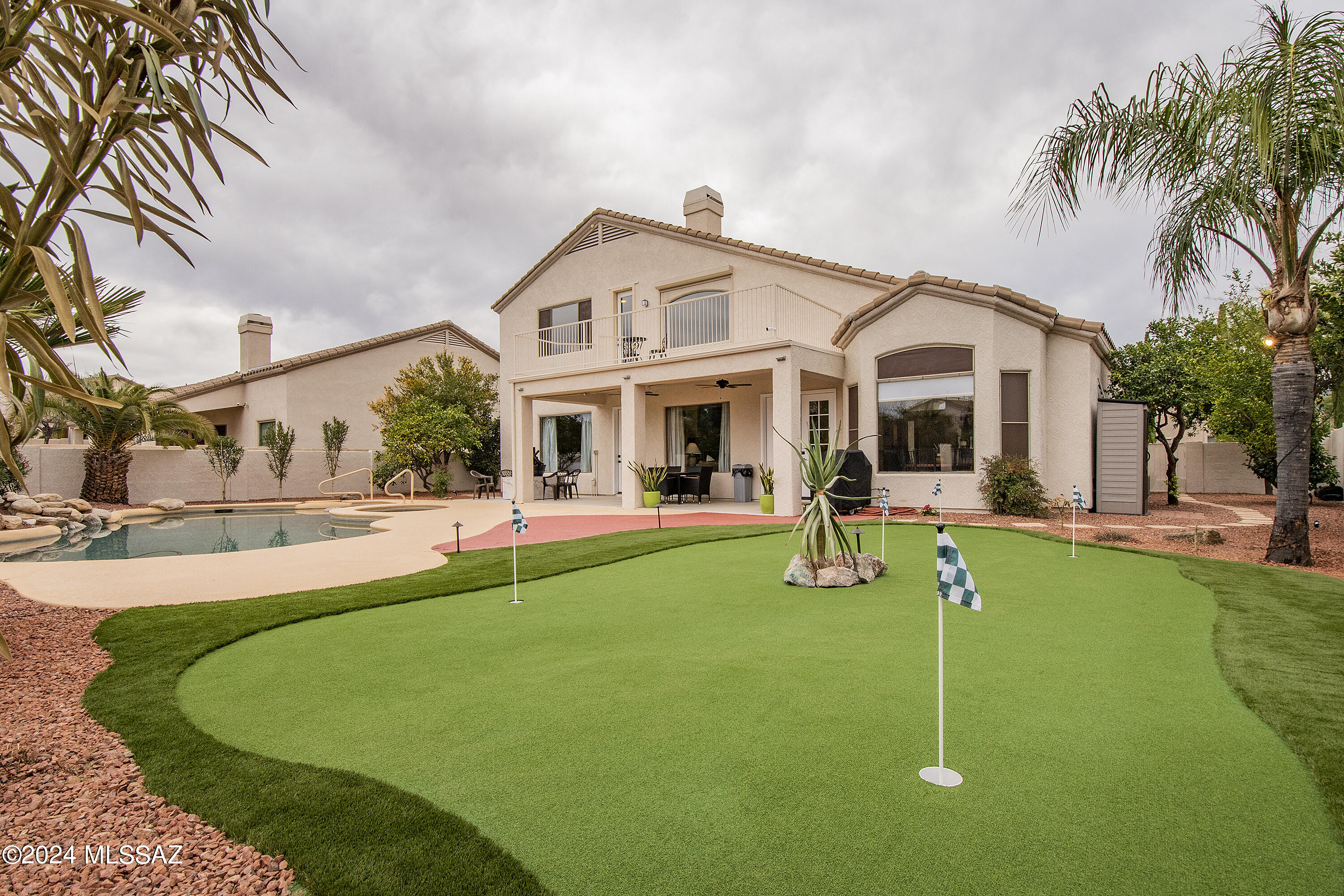 Beautifully remodeled 5BD/3BA home with soaring vaulted ceilings, ceramic tile flooring throughout, and a 3-car garage. The flexible 5th bedroom serves as an ideal bonus room, office, gym, media room, or guest space. Enjoy resort-style outdoor living with a sparkling pool, spa, putting green, outdoor shower, and breathtaking Catalina Mountain views. Situated in a quiet neighborhood with no rear neighbors, this home offers privacy and unforgettable sunsets. Smart home features include Rachio irrigation, Pentair auto pool filler, landscape lighting, Eufy cameras, and ADT security. A proven Airbnb performer since 2023. Furnishings available separately through a bill of sale and are negotiable. Move-in ready and impeccably maintained!
