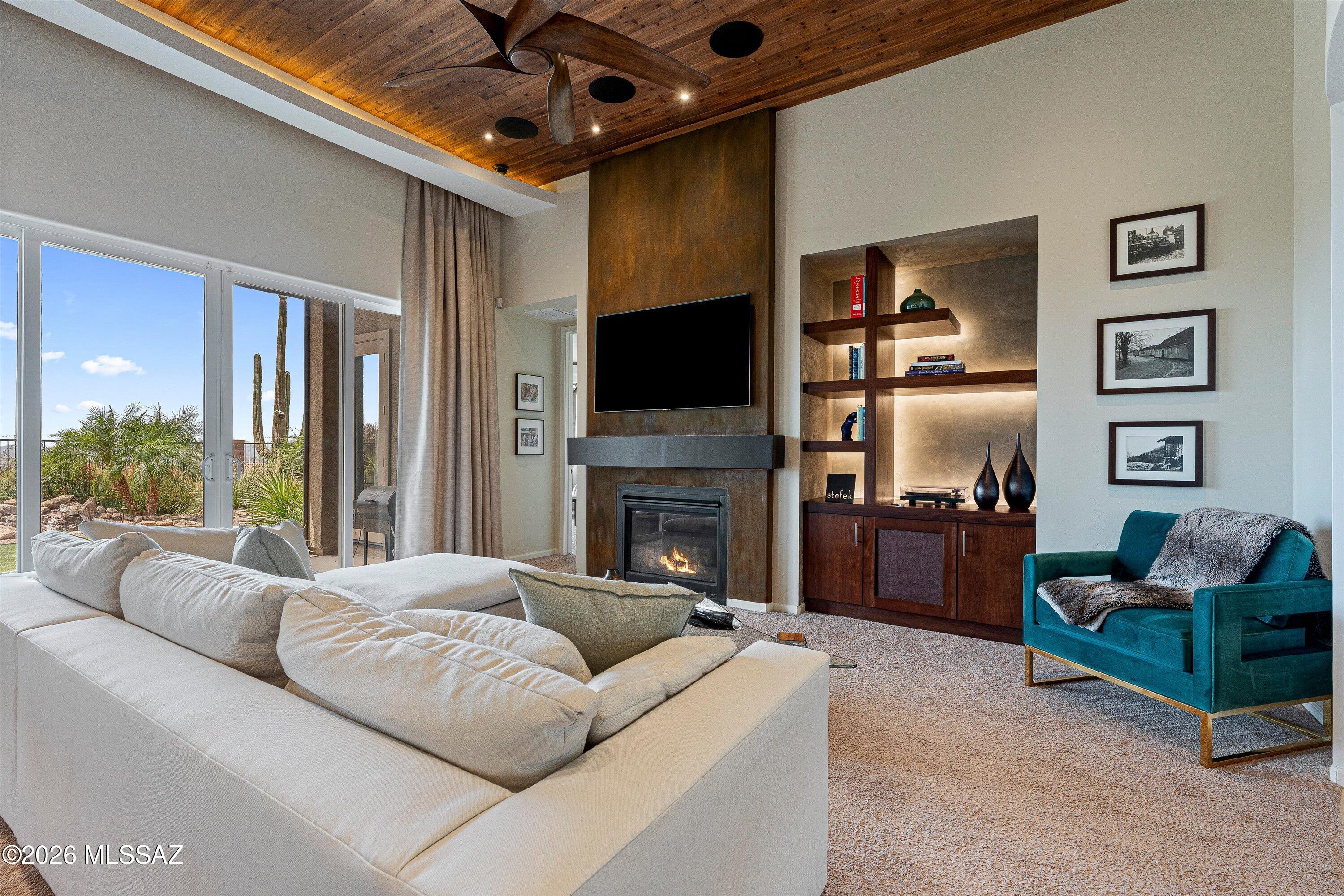 Welcome to an exceptional, fully upgraded single-story home in the highly sought-after Dove Mountain area of Marana--where design, quality, and attention to detail are evident in every space.
From the moment you arrive, the home makes a statement with a paver driveway, stacked stone accents, and professionally designed desert landscaping featuring agave, yucca, and mature plantings that create a warm and elevated curb appeal.
Step through the striking glass and steel entry door and you're immediately drawn to breathtaking views framed straight through the home--setting the tone for what's inside.
The great room is nothing short of impressive, featuring soaring wood plank ceilings with integrated lighting, a dramatic fireplace, and custom built-ins. Expansive glass doors open to the covered patio, creating seamless indoor-outdoor living and bringing Arizona's natural beauty into your everyday life.
The kitchen is a true showpiece--designed for both elevated entertaining and everyday living--with rich custom cabinetry, granite countertops, and a full-height designer mosaic backsplash that adds striking texture and depth. Anchoring the space is a professional Wolf gas cooktop with stainless hood, delivering both performance and presence, while double wall ovens enhance functionality for hosting and daily use. The custom Sub-Zero refrigerator seamlessly integrates into the cabinetry, offering top-tier performance with a refined, built-in aesthetic. The oversized island with undermount sink serves as the central gathering point, providing generous prep space and effortless flow into the surrounding living areas. Glass-front cabinetry, under-cabinet lighting, and thoughtfully integrated storage further elevate the space, while a custom built-in bar/coffee station adds both convenience and a refined touch of everyday luxury.
In addition to the main living area, a separate flex living space offers versatility for a lounge, media room, or additional entertaining area--enhancing both functionality and flow throughout the home.
The primary suite offers a private retreat with a spacious bedroom and a spa-inspired bathroom featuring dual vanities, upgraded finishes, and designer lighting. The custom walk-in closet is truly next level--complete with floor-to-ceiling cabinetry and glass display features, creating a boutique-style experience rarely found.
Secondary bedrooms are thoughtfully positioned and connected by a well-appointed Jack & Jill bathroom with dual sinks, upgraded cabinetry, and stone surfaces, providing both convenience and privacy.
A beautifully appointed powder room offers added convenience for guests, featuring upgraded fixtures and a clean, modern design that complements the home's elevated finishes.
Step outside to a backyard designed for both relaxation and low-maintenance living. The extended covered patio overlooks a beautifully finished yard complete with synthetic turf, a tranquil water feature, and mature desert landscaping--all designed to maximize enjoyment with minimal upkeep.
Additional features include a spacious garage, upgraded systems, and a truly move-in-ready condition that reflects pride of ownership throughout.
Located in the prestigious Dove Mountain community, this home offers proximity to world-class golf, the Ritz-Carlton, and stunning desert surroundings--all while delivering the elevated lifestyle buyers are searching for.