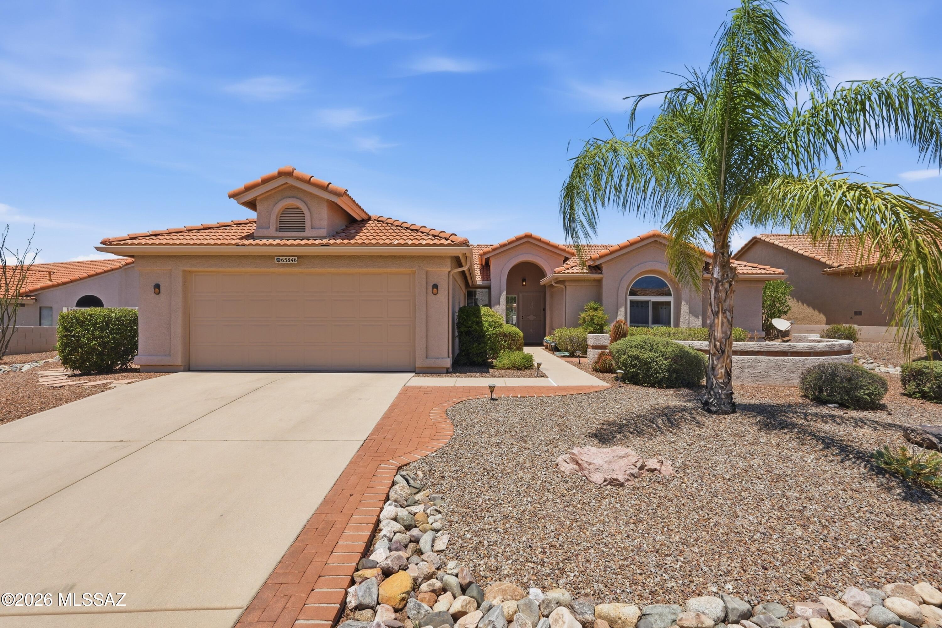 Discover a beautifully maintained and thoughtfully modified retreat in the heart of SaddleBrooke, Southern Arizona's premier 55+ active-adult golf community. This 2BD/2BA (2,204 sqft) Topaz model offers tons of bright, airy living space. This popular floorplan has been expertly expanded to offer rare versatility, incredible storage, and effortless single-story convenience. From the front entryway protected by high-quality security doors, step inside to a light-filled neutral color palette accentuated by soaring vaulted ceilings. This home's footprint uniquely prioritizes lifestyle flexibility, featuring a two-foot extension added directly to both the guest bedroom and the private office/den. Cooking and entertaining are seamless in the central kitchen, which boasts durable Corian countertops with an integrated sink, passing seamlessly into a spacious breakfast nook and a warm great room hub. Bridging the kitchen and the garage is a large, dedicated hobby and craft room illuminated by a Solatube skylight, offering the perfect studio space for artists, or specialized storage. The interior transitions effortlessly into a gorgeous backyard haven, designed for peaceful desert enjoyment. Positioned on an expansive lot, the fully landscaped rear yard offers exceptional privacy for relaxation. Spend quiet mornings or host lively afternoon gatherings on the covered brick patio, complete with an extended seating area and an elevated masonry planter box. Practicality matches the home's beauty, anchored by a rare 8-foot garage extension that provides ample room for full-sized vehicles, workshop benches, or golf cart storage. Residents enjoy immediate access to SaddleBrooke's elite community amenities, including championship golf courses, tennis courts, resort-style pools, fitness centers, and miles of scenic walking paths backdropped by the majestic Catalina Mountains.