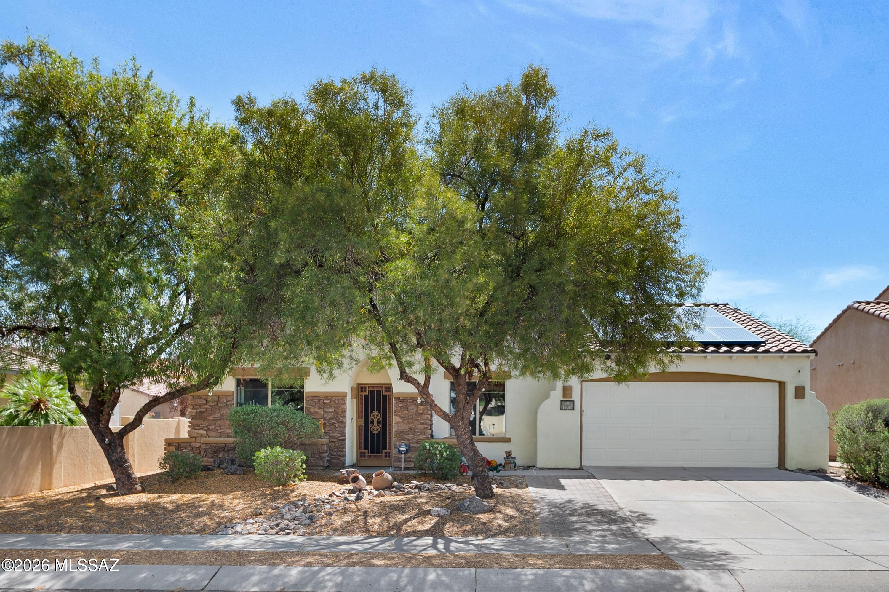 Welcome to your next chapter in the highly sought-after Rancho Sahuarita community! Nestled within the desirable Presidio De La Madera neighborhood, this beautifully maintained and thoughtfully upgraded 5-bedroom, 3-bath residence offers the perfect blend of comfort, functionality, energy efficiency, and Arizona lifestyle living. From the moment you arrive, the attractive stone façade and inviting curb appeal immediately set the tone for what awaits inside.

Step through the front door and experience a spacious, light-filled floor plan designed for both everyday living and entertaining. The downstairs living areas feature easy-to-maintain hard surface flooring, including tile and laminate throughout, creating a clean and modern feel while eliminating the hassle of downstairs carpet. The versatile downstairs den offers exceptional flexibility and can easily function as a true 5th bedroom, home office, guest retreat, or multi-generational living space thanks to its full closet, window, and convenient proximity to a full bathroom--perfect for visiting family members or anyone looking to avoid stairs.

The heart of the home is the generously sized kitchen, designed with both style and practicality in mind. Featuring stainless steel appliances including a refrigerator and dishwasher, abundant cabinetry, extensive counter space, and a center island that overlooks the family room, this kitchen creates the ideal setup for hosting gatherings or enjoying quiet evenings at home. The adjoining family room is warm and inviting with a cozy fireplace that adds charm and ambiance to the space.

Upstairs, you'll find an expansive primary suite designed to be your own private retreat. One of the standout features of this home is the oversized covered balcony extending directly off the primary bedroom--offering breathtaking views of the backyard and the beautiful Santa Rita Mountains. This elevated outdoor space also serves as a covered patio below, creating additional shade and functionality for outdoor living. Imagine enjoying your morning coffee while watching the sunrise over the mountains or unwinding in the evenings while taking in Arizona's stunning desert skies. The spacious primary bathroom features dual vanities, a soaking tub, separate shower, and a generously sized walk-in closet designed to accommodate your storage needs with ease.

The upstairs level also includes three additional guest bedrooms, providing flexibility for growing households, guests, hobbies, or additional workspace options. To make this home even more move-in ready, the upstairs is receiving brand-new carpet installation for the new owner--adding fresh comfort and value throughout the second level.

This home has been meticulously cared for and offers numerous major upgrades that provide peace of mind and long-term value, including a new roof installed in 2023, select new windows in 2023, fresh exterior paint completed in 2025, and a brand-new 2.5-ton HVAC system installed in 2025. Energy-conscious buyers will appreciate the Tesla solar system and EV charger, helping contribute to significantly reduced utility costs during the warm Arizona summers while supporting a more energy-efficient lifestyle.

Step outside into your private backyard oasis where relaxation and entertaining come together seamlessly. The backyard features low-maintenance turf, mature landscaping, multiple water features, and a spacious covered patio ideal for outdoor dining, gatherings, or simply enjoying the peaceful surroundings. The thoughtful landscaping creates a tranquil atmosphere while still remaining easy to care for year-round.

The 3-car tandem garage provides excellent storage capabilities and versatility for vehicles, recreational equipment, home gym space, workshop potential, or additional storage solutions.

Living in Rancho Sahuarita means gaining access to an incredible master-planned community known for its resort-style amenities and vibrant lifestyle. Enjoy nearby lakes, parks, walking and biking trails, water park amenities, recreational facilities, community events, and convenient access to shopping, dining, and everyday essentials. This location offers the perfect balance of neighborhood charm and modern convenience.

Opportunities like this are hard to find--a spacious, extensively upgraded, energy-efficient home in one of Southern Arizona's most desirable communities. Whether you're looking for room to grow, space to entertain, or simply a beautifully maintained move-in-ready home with stunning mountain views, this property truly checks all the boxes.

Schedule your private showing today and experience everything this exceptional home in Rancho Sahuarita has to offer before it's gone!