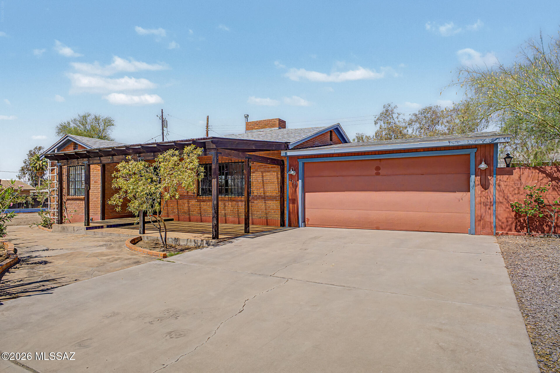 Located in the heart of Central Tucson - walking or biking distance from the University of Arizona. Discover this adorable red brick home situated on a prime corner spacious lot. This gem boasts attractive landscaping, an inviting front covered porch, new roof w/warranty, freshly painted throughout interior & a spacious 2-car garage + additional storage space. The interior showcases tile flooring throughout, a wood-look paneling accent wall, plenty of natural light, & a cozy wood burn fireplace. The modern kitchen boasts new stove & microwave, ample wood cabinetry, tile backsplash, spacious counters, a breakfast bar, & built-in essentials . You'll love the two spacious bedrooms, one of which features a private exit for convenience. Spacious backyard is private with custom gates for entry. Entire home was deep cleaned in June 2026.  Heating & cooling have been professionally serviced & are in great working order as of June 2026.     Exterior trim recently painted.  The home is move in ready.  Come take advantage of a great price, in a convenient, Central location of town near bus lines, restaurants, free-way, shopping, & offices .  Neighborhood park just walking distance from the home.
