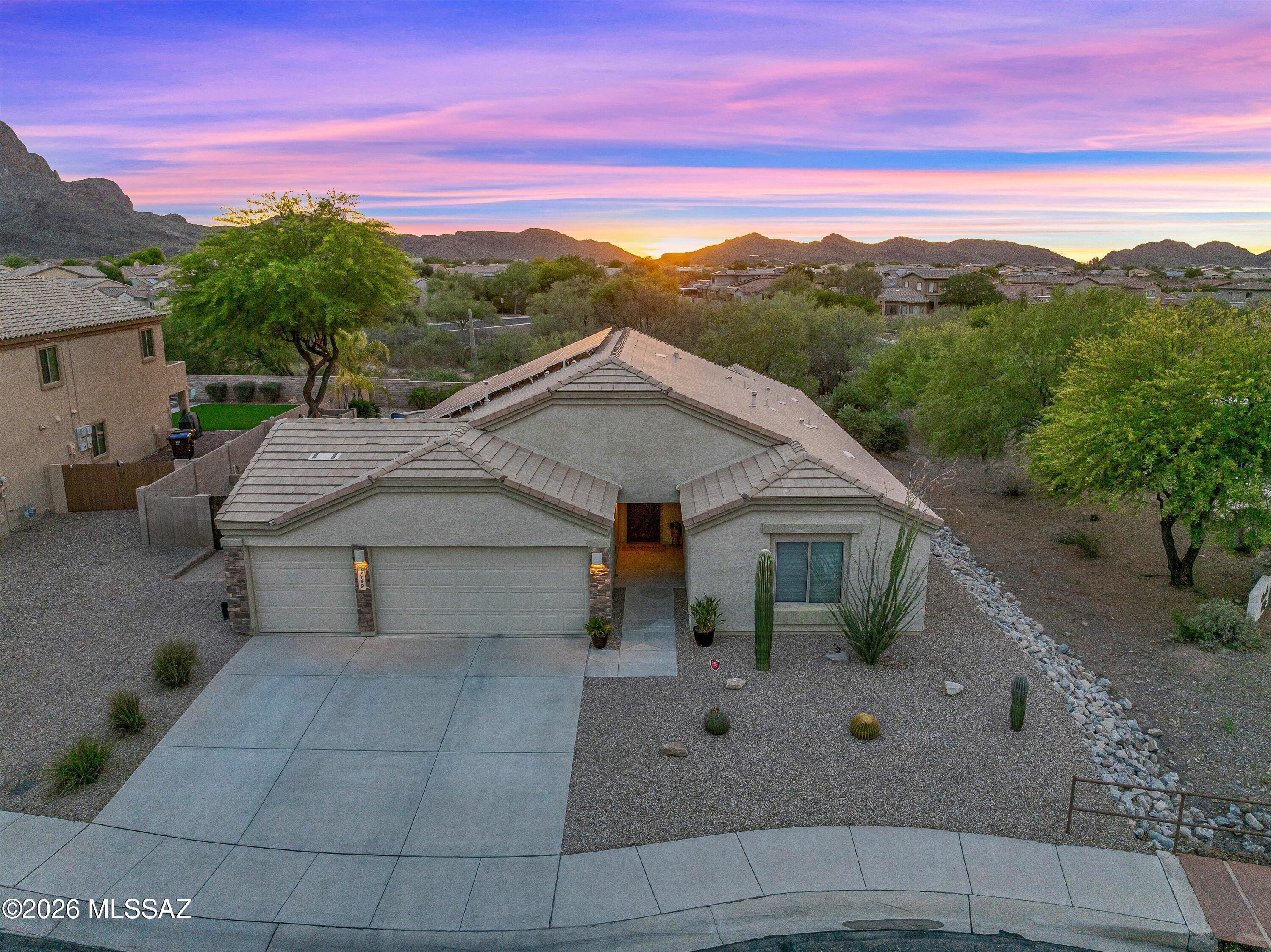 Welcome home to this beautifully upgraded Northwest side retreat where luxury, comfort, and Arizona outdoor living come together seamlessly. From the moment you arrive, the curb appeal stands out with fresh landscaping, a custom security door, and a premium corner lot location backing to common desert space with stunning mountain views.

Step inside and immediately notice the bright open floor plan, soaring ceilings, fresh paint, updated lighting/fixtures, and newly refinished concrete floors that create a clean, modern feel throughout the home. The spacious living area is designed for both relaxing and entertaining, complete with surround sound wiring and large windows that bring the desert views indoors. French doors lead to a versatile den or office space, perfect for working from hom a media room, or additional guest space.

The heart of the home is the beautifully upgraded kitchen featuring granite countertops, custom cherry wood upper and lower cabinetry with pull-out shelving, custom stone inlay accents, GE stainless steel appliances, a gas range, oversized island, reverse osmosis system, and generous storage throughout. Every detail was thoughtfully designed for both style and functionality.

The primary suite offers a peaceful retreat with spa-like touches including a refinished concrete shower. Additional upgrades throughout the home include owned solar, water softener and treatment system, alarm system with motion detector, newer water heater (2024), and newer microwave (2024).

Step outside and experience your own private resort-style backyard. Designed for entertaining, the outdoor space features a Pebble Tec pool with in-floor cleaning system, waterfall feature, outdoor shower, raised garden beds, turf and pavers, expanded side yard, and breathtaking sunset views with an occasional hot air balloon sighting over the surrounding mountains and desert landscape. The fully equipped outdoor kitchen includes a built-in grill, refrigerator, concrete counters, tiled backsplash, and metal pergola creating the ultimate Arizona entertaining space.

The oversized 3-car garage includes built-in shelving and workspace for added convenience and storage. Even better, the home includes the mounted 65-inch Samsung TV, LG washer and dryer, outdoor grill, and outdoor refrigerator making this truly move-in ready.

Only a quick drive to I10, shopping, dining, parks, and schools. This exceptional home offers the perfect blend of luxury upgrades, energy efficiency, and unforgettable desert living!

Refrigerator in kitchen and garage shelving/rack systems do not convey.