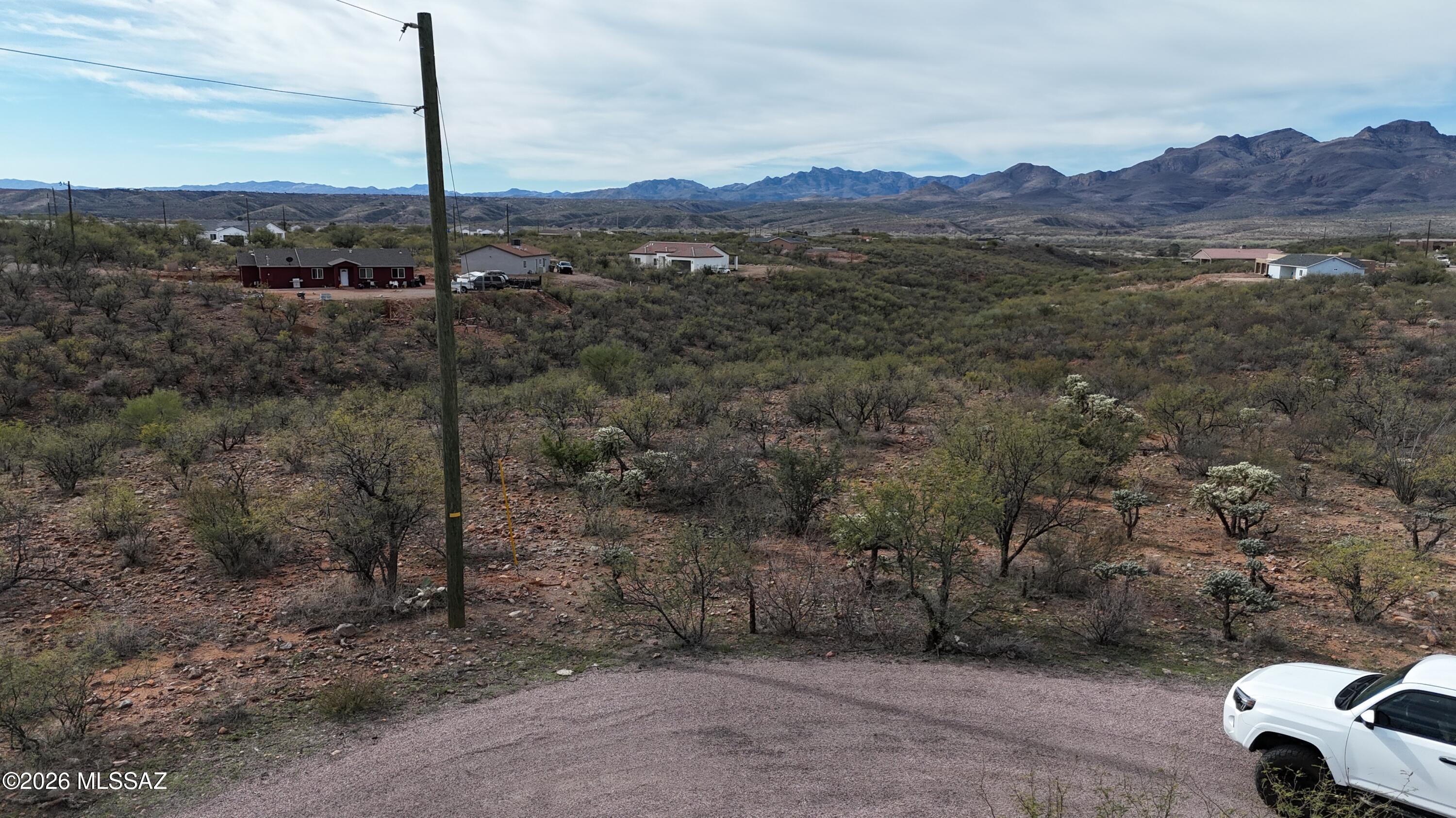 Large residential lot with gentle downhill slope at the end of a cul de sac.  There are power poles at the street and the water main is at the street.  Paved road, mountain views.