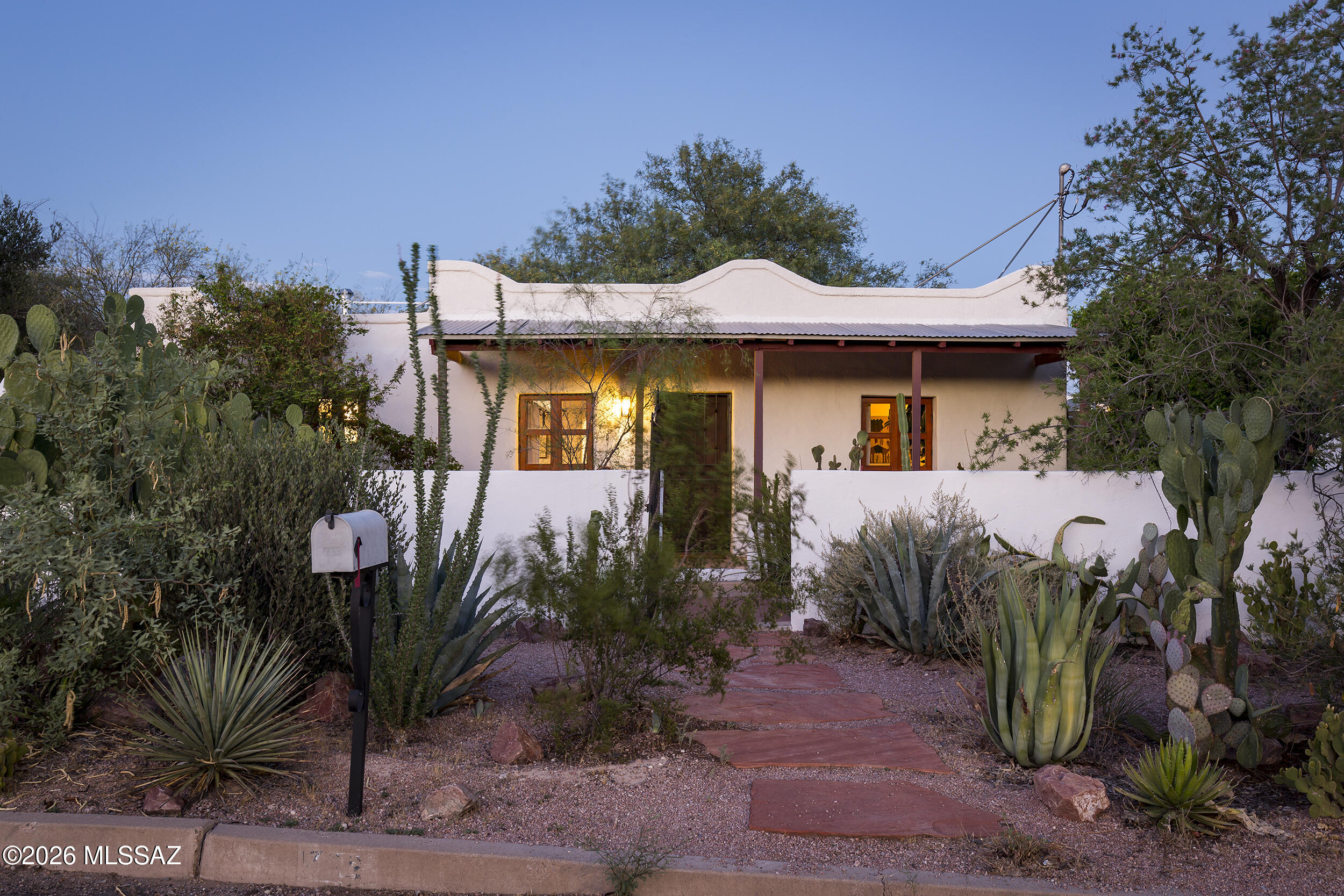 Located in Tucson's Historic Barrio Libre (AKA Barrio Viejo), this c.1939 mud adobe embodies the quiet beauty and enduring craftsmanship that define the city's earliest neighborhoods. Thick adobe walls provide remarkable thermal mass, naturally helping to moderate interior temperatures throughout the year, a timeless example of architecture designed to work in harmony with the Sonoran Desert. Inside, hardwood and polished concrete floors, high wood-plank and beamed ceilings, handcrafted casement windows, and two thoughtfully appointed full baths, including one with a classic clawfoot tub, create spaces that feel both authentic and inviting. Every room reflects a quiet simplicity, yet the longer you spend here, the more the craftsmanship reveals itself. From the subtle proportions to the carefully executed details, this is a home that rewards a slower look.   Brick-paved courtyards, generous front porches, mature native landscaping, water-harvesting tanks, and an owned solar system reflect a continued respect for the home's historic character while embracing sustainable desert living.  The detached studio, currently serving as a creative workspace, feels like the kind of place where paintings, pottery, novels, or music naturally come to life. Standing inside, it's hard not to wish you had devoted your own life to some artistic pursuit and mastered a creative craft. This is more than a historic adobe. It's crafted with intention, shaped by the desert, and lovingly stewarded through generations.