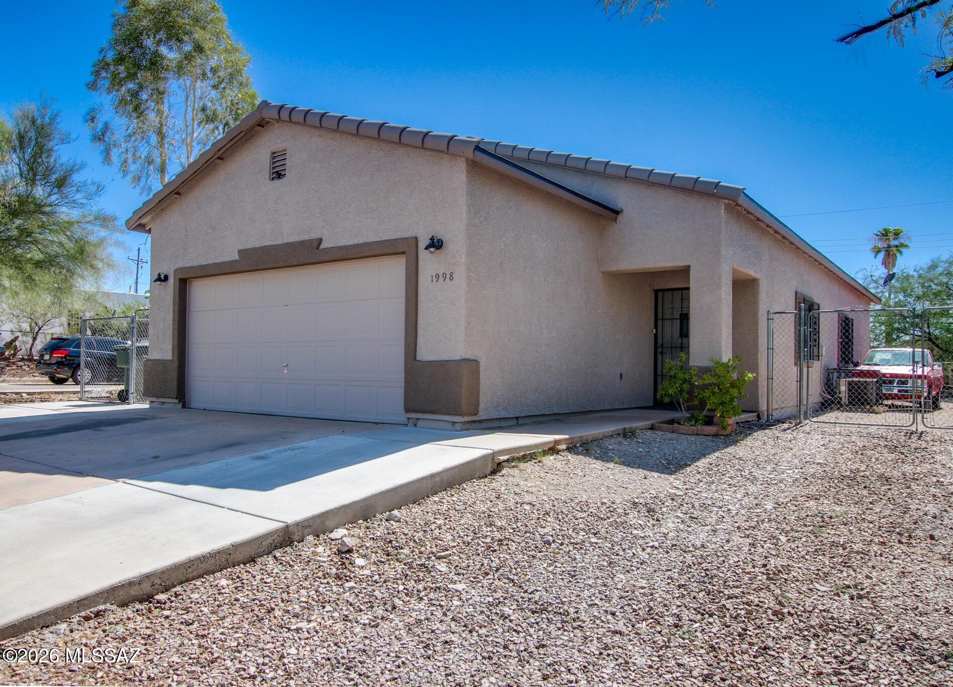 Welcome home to this 3-bedroom, 2-bath home featuring an open floor plan, tile flooring throughout, and leased solar for added energy efficiency. Roof replaced in 2025. The spacious kitchen offers abundant counter space, ample cabinetry, and a breakfast bar, making it perfect for everyday living and entertaining. Both bathrooms have been tastefully updated. A versatile bonus room within the garage provides the ideal space for a home office, gym, or hobby room and can easily be converted back to full garage space if desired. Enjoy the large backyard with plenty of room to relax, garden, or entertain. Conveniently located near downtown with easy freeway access, this home offers comfort, flexibility, and an excellent location. No HOA!