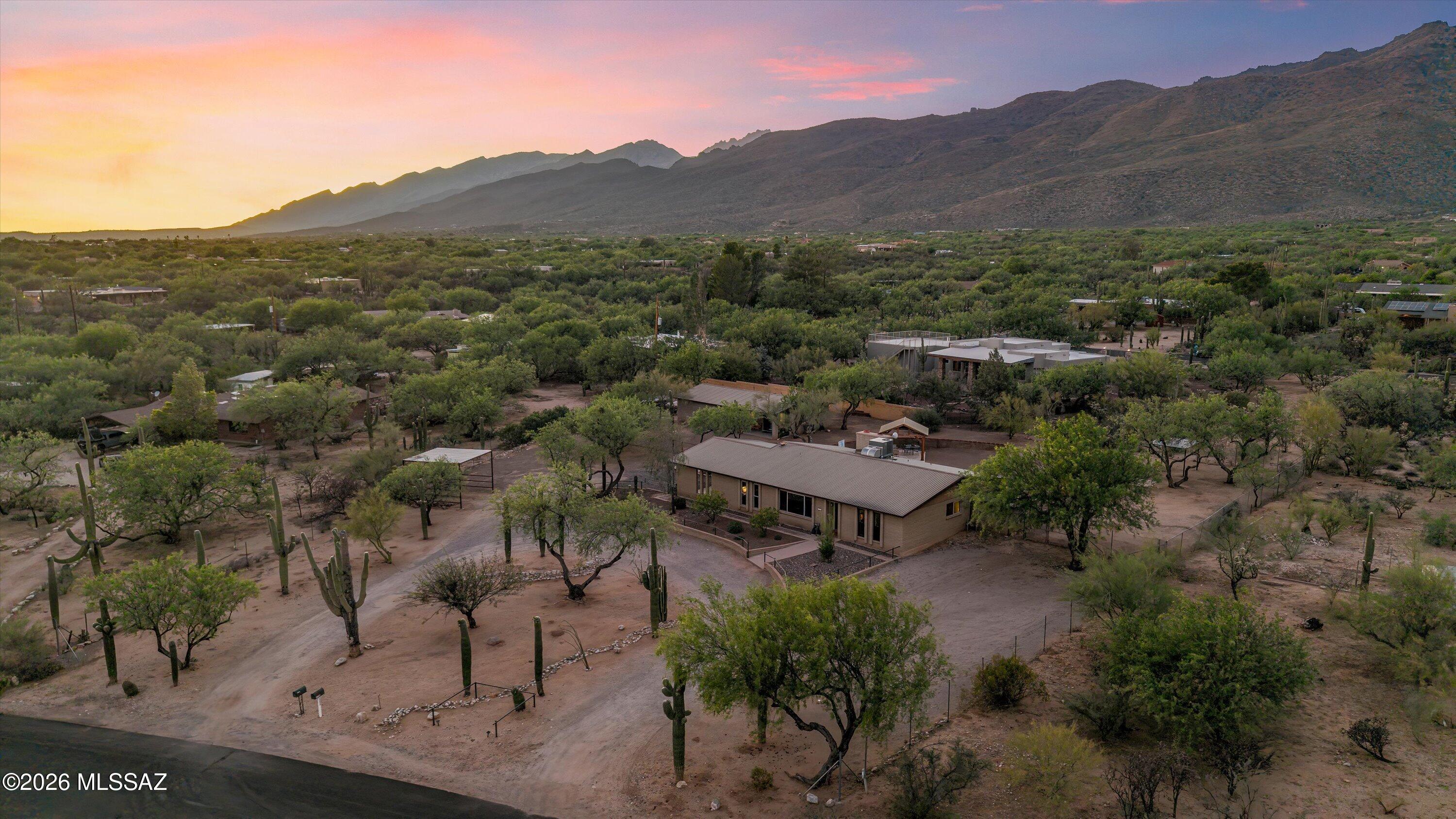 Seller will accept or counter within range. Welcome to your own slice of serenity. This Tanque Verde Valley Ranch home has privacy, land, & stunning mountain views! The main ranch home is an open concept with 3 bedroom, 2 bath plus den with charming brick wood-burning fireplace, metal roof with gutters and newer dual pane windows. Beautifully updated kitchen features subway tile backsplash, recycled glass countertops, newer cabinets and stainless steel appliances, including gas range & hood. Cabinetry & counter top extends into dining room for additional storage and buffet.  Primary Bedroom has updated bathroom with walk-in shower and backyard access to outdoor shower.  Hall bathroom updated, wood plank tile throughout. Walk out to covered & tiled patio, sparking pool with new equipment, shady ramada and expansive mountain views! Separate 1 bedroom 1 bath guest house, has full kitchen and has completely remodeled. Attached to the guest house is an oversized 3 car garage. There is additional covered separate parking/horse structure and the house has 2 car carport. With nearly an acre you have plenty of room for your toys, animals, family and no HOA!