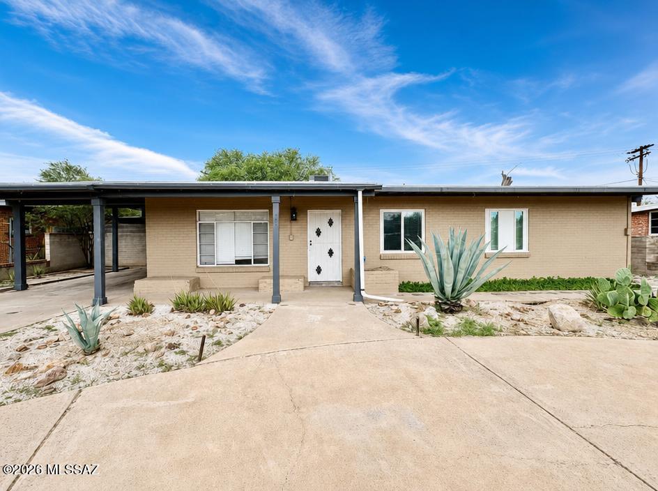 Perfect starter home or investment opportunity! Adorable 3 bedroom/2 bathroom, brick ranch style home in central Tucson. Tile Floors throughout, and spacious kitchen/living area. HUGE, meticulously decorated backyard with turf and pavers and desert landscaping. Plus mature tree for shade. Covered Patio spans the length of the home, and includes outdoor laundry room and shed for additional storage. NO backyard neighbors, home backs up to Arroyo Chico Wash. Access to the backyard through the primary bedroom! Primary bedroom includes walk-in shower. Other two bedrooms are spacious with trendy sliding barn doors. Front yard features horseshoe driveway AND one car carport. HVAC replaced in 2024. This home is ready to move in and make your own!