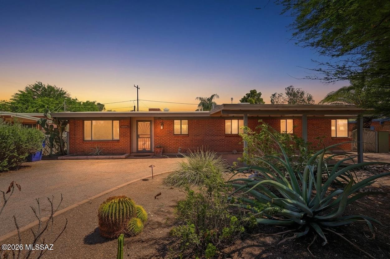 Amazing opportunity for move-in ready 3 bed/2 full bath, 1,620 SqFt single story 1954 mid-century modern red brick ranch home on .19 acre R-1 lot, the freedom of no HOA, located in desirable Highland Vista neighborhood, walking distance to Highland Vista Park including large grassy field, playground, Highland Vista Community pool (voluntary membership for pool use), Community Garden's sponsored garden and year-round neighborhood events. Experience the best of both worlds with the vintage character and charm you are seeking with modern amenities, the perfect solution for those looking for an Airbnb investment property, rental (rented for $1950 a month), seasonal visitors (no stairs/no steps), secure student housing, and first time home buyers alike! 
N/S orientation provides daily Catalina Mountain views from the front of the home. A large circular driveway with drive-thru carport offers abundant on- and off-street parking, hardwired landscape lighting, raised concrete flower garden, granite rock basin, shade providing mature mesquite tree, while mature lush landscaping creates exceptional curb appeal and privacy.
Inside, buyers will appreciate tile flooring throughout with no carpet, soaring vaulted wood-beam ceilings, exposed wire-cut brick walls, dual cooled with gas HVAC and swap cooler options, Nest smart digital thermostat, plantation wood shutters, and a spacious living room filled with natural light. The centerpiece of the home is a stunning floor-to-ceiling red brick, double-sided wood-burning fireplace with a flagstone hearth, beautifully anchoring the living and dining spaces while adding warmth, character, and timeless Southwestern charm.
The cozy open kitchen features real wood painted cabinetry, tiled countertops, stainless steel appliance package with white gas stove, refrigerator, and dishwasher, plus a double metal sink perfectly positioned beneath a garden window.
Adjacent to the kitchen is a formal dining area highlighted by impressive energy-efficient multi-slide glass patio doors. All three panels glide effortlessly and stack neatly to one side, creating a dramatic wall of glass that seamlessly blends indoor and outdoor living. This architectural feature floods the home with natural light and captures the essence of mid-century modern design, extending the living space onto the patio for effortless entertaining and everyday enjoyment.
Large guest bedrooms feature rare mitered corner windows, creating a dramatic floating-glass effect that showcases a signature element of mid-century modern architecture while filling the rooms with natural light. The updated guest bathroom offers a tiled vanity countertop and a tiled shower/tub. The spacious primary suite features an updated ensuite bathroom with a tiled shower/tub combination, plus a dedicated internal laundry and storage room with washer and dryer included.
Step outside and enjoy tranquil Tucson evenings beneath the extended covered patio overlooking the beautifully landscaped tiered backyard. Designed for both relaxation and low-maintenance living, the outdoor space features mature native desert vegetation, brick paver walkways, raised flower gardens, brick planter, fruit trees, a storage shed, and a gated metal side yard with convenient alley access. Surrounded by privacy block walls, this backyard retreat provides the perfect setting for entertaining, gardening, or simply enjoying Tucson's weather year round.
Conveniently located in the heart of Central Tucson with an impressive 92 Bike Score, this home is a short distance from Duff Elementary School, Rincon High School, and Arizona College of Nursing. Just minutes from grocery stores, shopping, restaurants, movie theaters, Park Place Mall, the University of Arizona, Banner Medical Center, Tucson Medical Center, and Davis-Monthan Air Force Base. Don't miss this opportunity to own a classic mid-century modern home in a prime Central Tucson location!