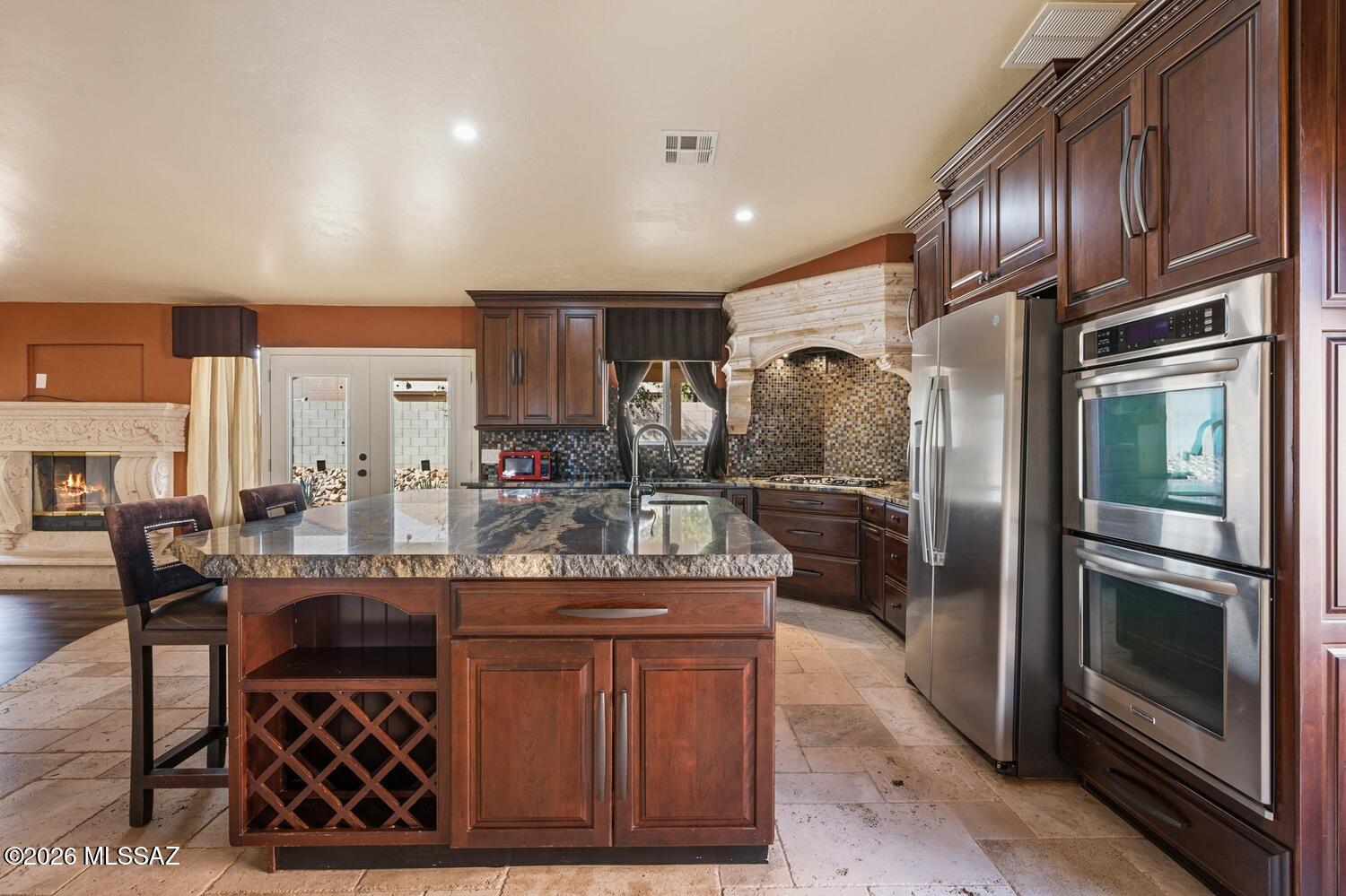 Very rare find! Stunning remodeled home with upgrades normally found only in high-end luxury homes! This open, immaculate, move-in ready home features the most AMAZING gourmet island kitchen with beautiful custom cabinetry, granite counters, top-notch SS appliances including a 5 burner gas stove with custom vent hood. Travertine tile, and brand new wood flooring throughout, solid wood doors, and the Great Room showcasing a Cantera-Travertine F/P. Gorgeous, totally remodeled bathrooms with beautiful wood cabinetry, granite counters, and Travertine-tiled showers. Security system, southwest colors throughout. Brand new shingled roof with roof warranty, and a brand new heating-  A/C cooling system. New colored gravel on exterior grounds. Brand new exterior doors. You'll be saying ''OH WOW!
